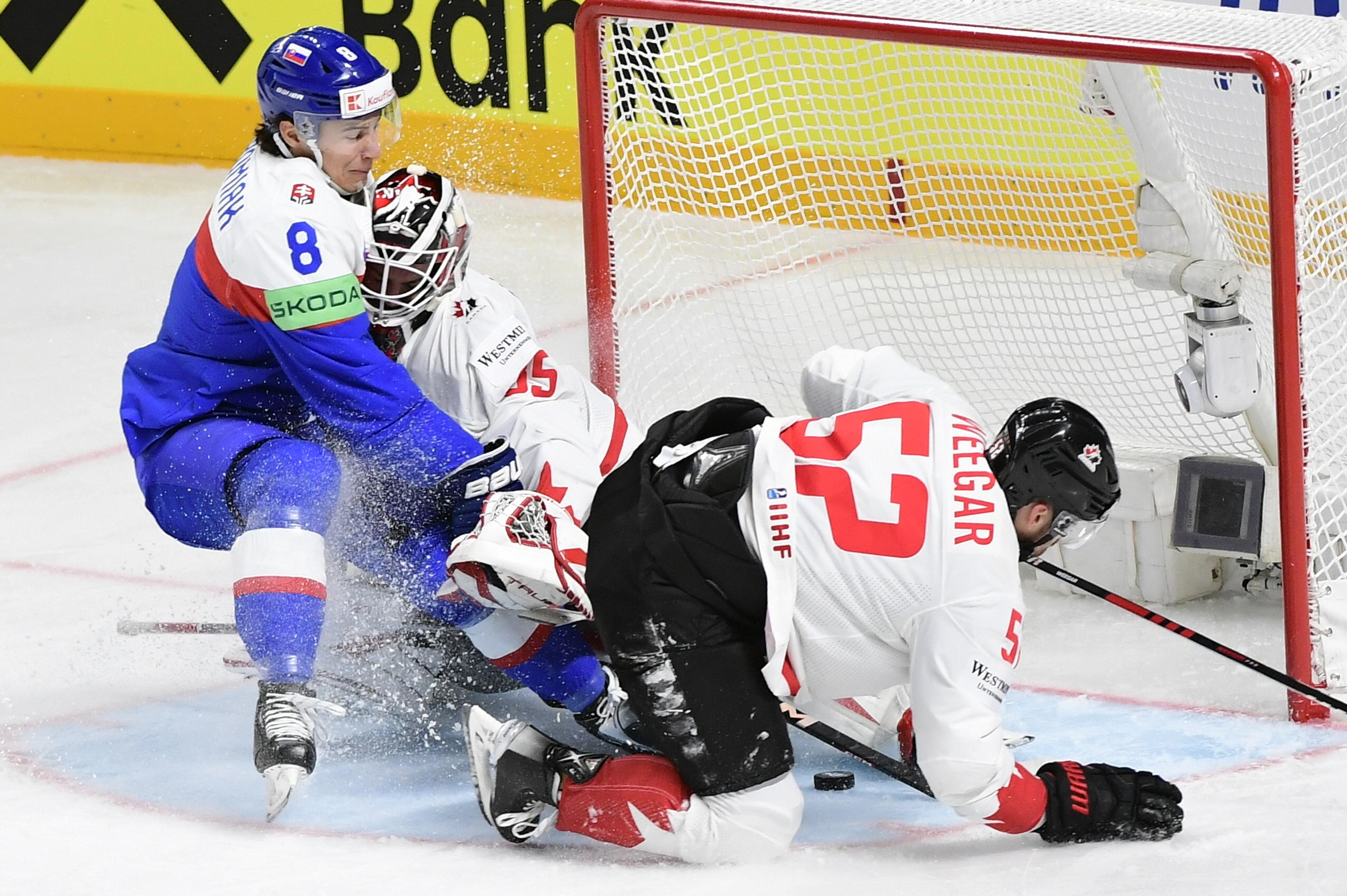 Na snímke uprostred brankár Kanady Samuel Montembeault, vpravo jeho spoluhráč a obranca MacKenzie Weegar, vľavo slovenský útočník Martin Chromiak.