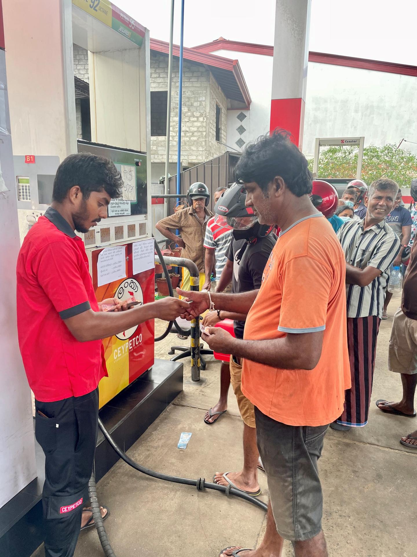 Muž platí za benzín