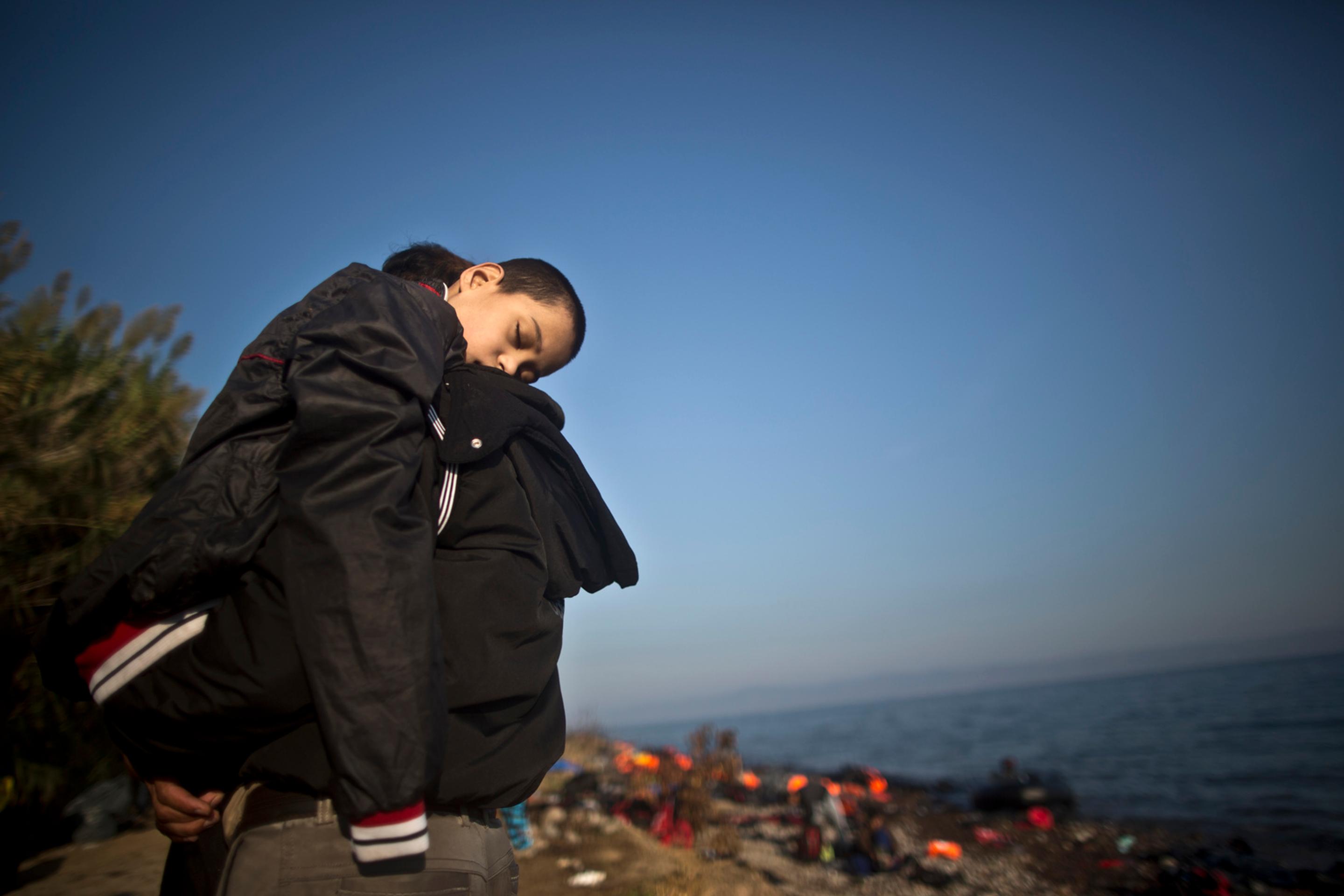 Utečenec nesie na rukách svojho syna