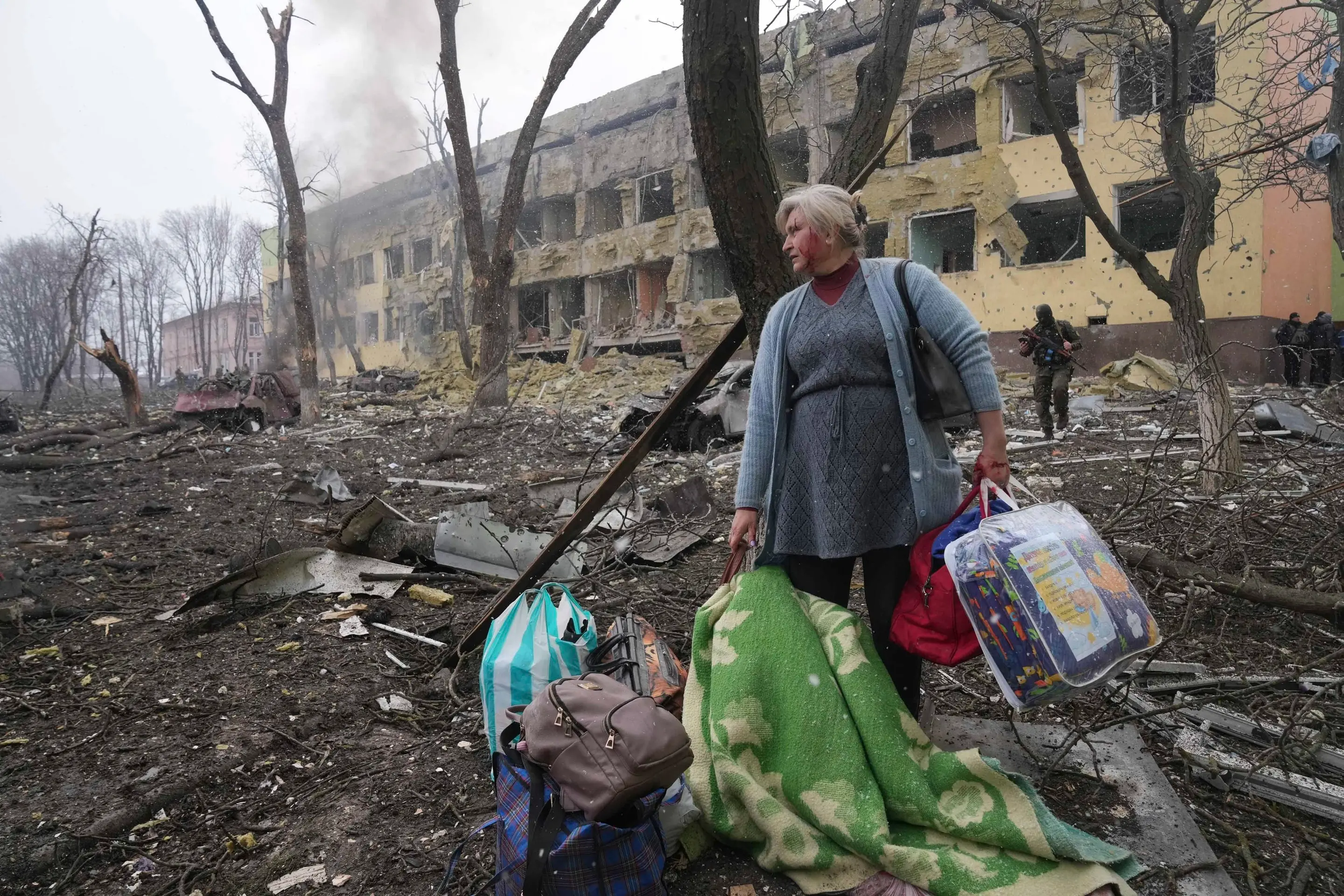 Žena pred bombami zničenou pôrodnicou v Mariupole.