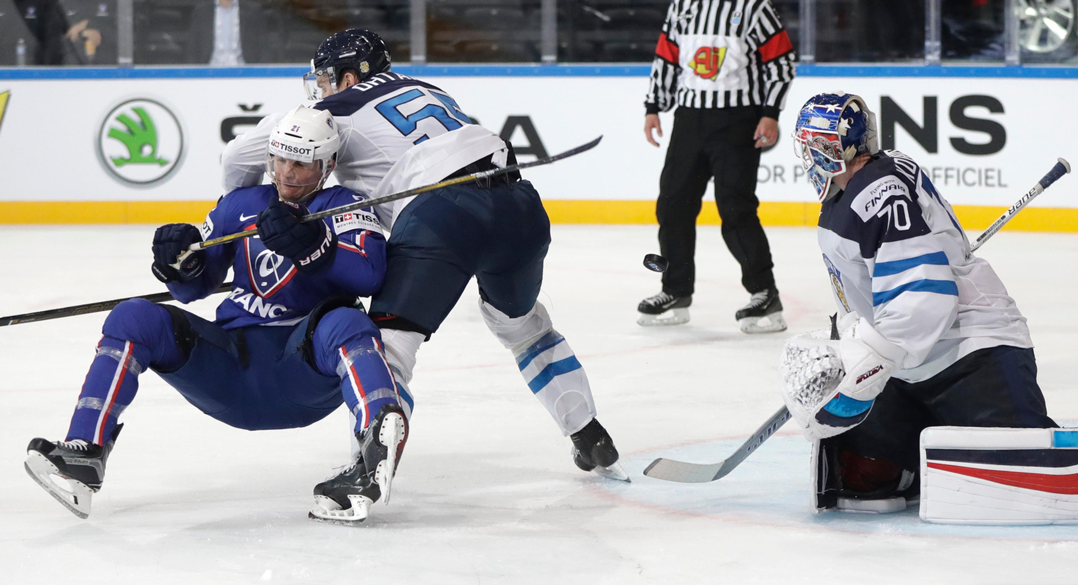 Gólman Fínska Joonas Korpisalo (vpravo) sleduje súboj Atteho Ohtamaa s Francúzom Antoine Rousselom.