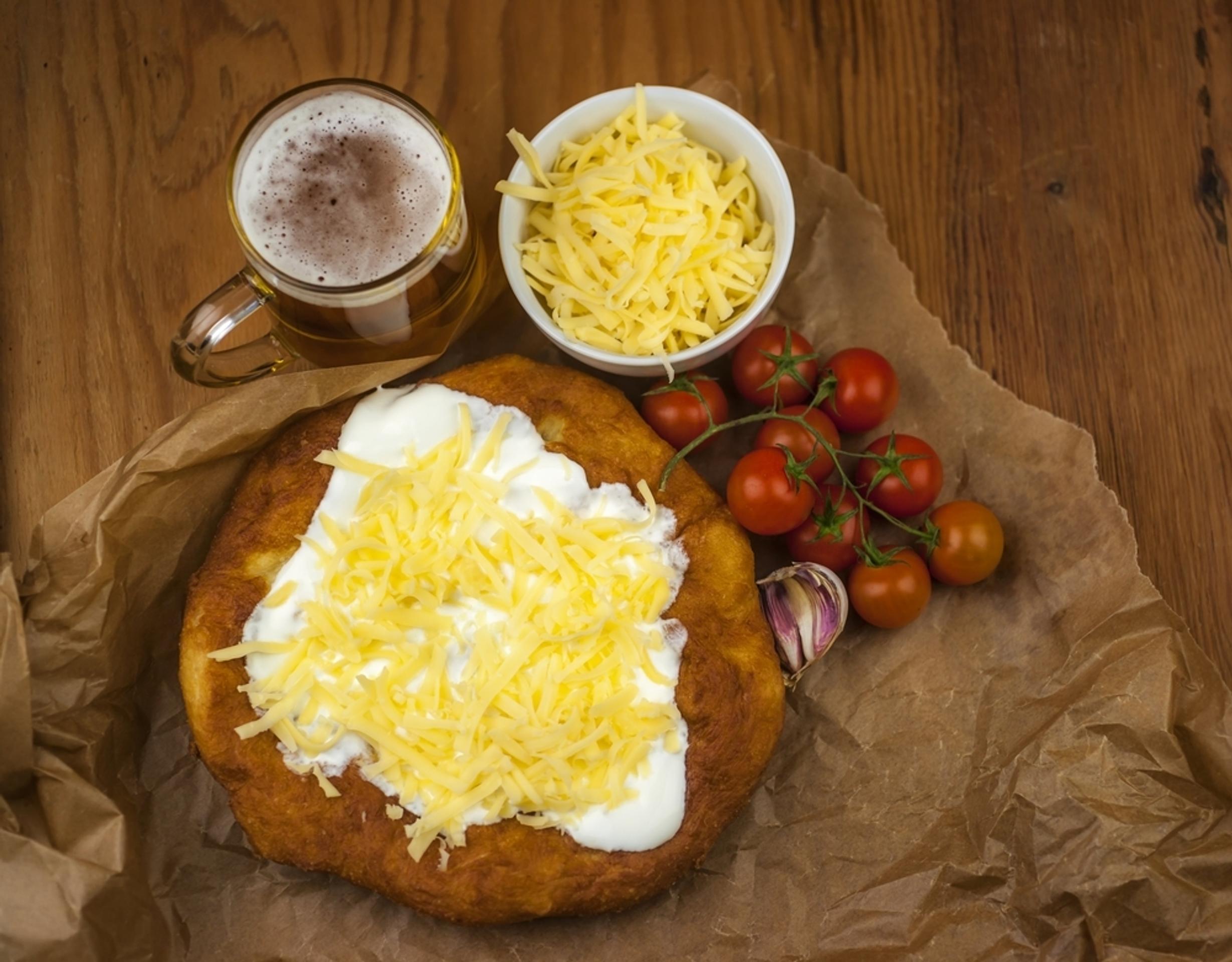 Langoš so smotanou, slaninou, cibuľou a syrom. 