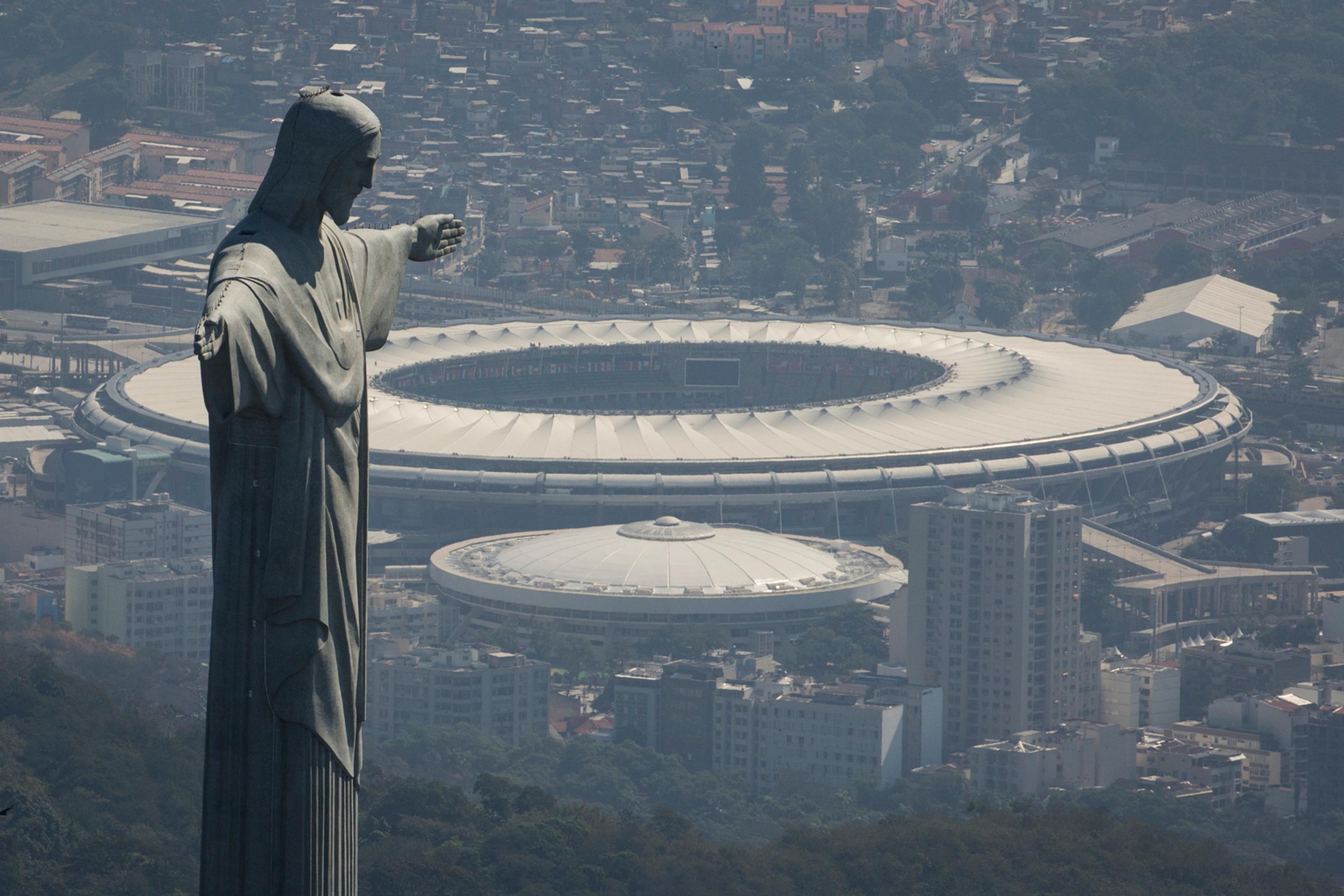Na snímke gigantická socha Krista Spasiteľa, ktorá je umiestená na vrchu Corcovado, a za ňou štadión Maracaná.