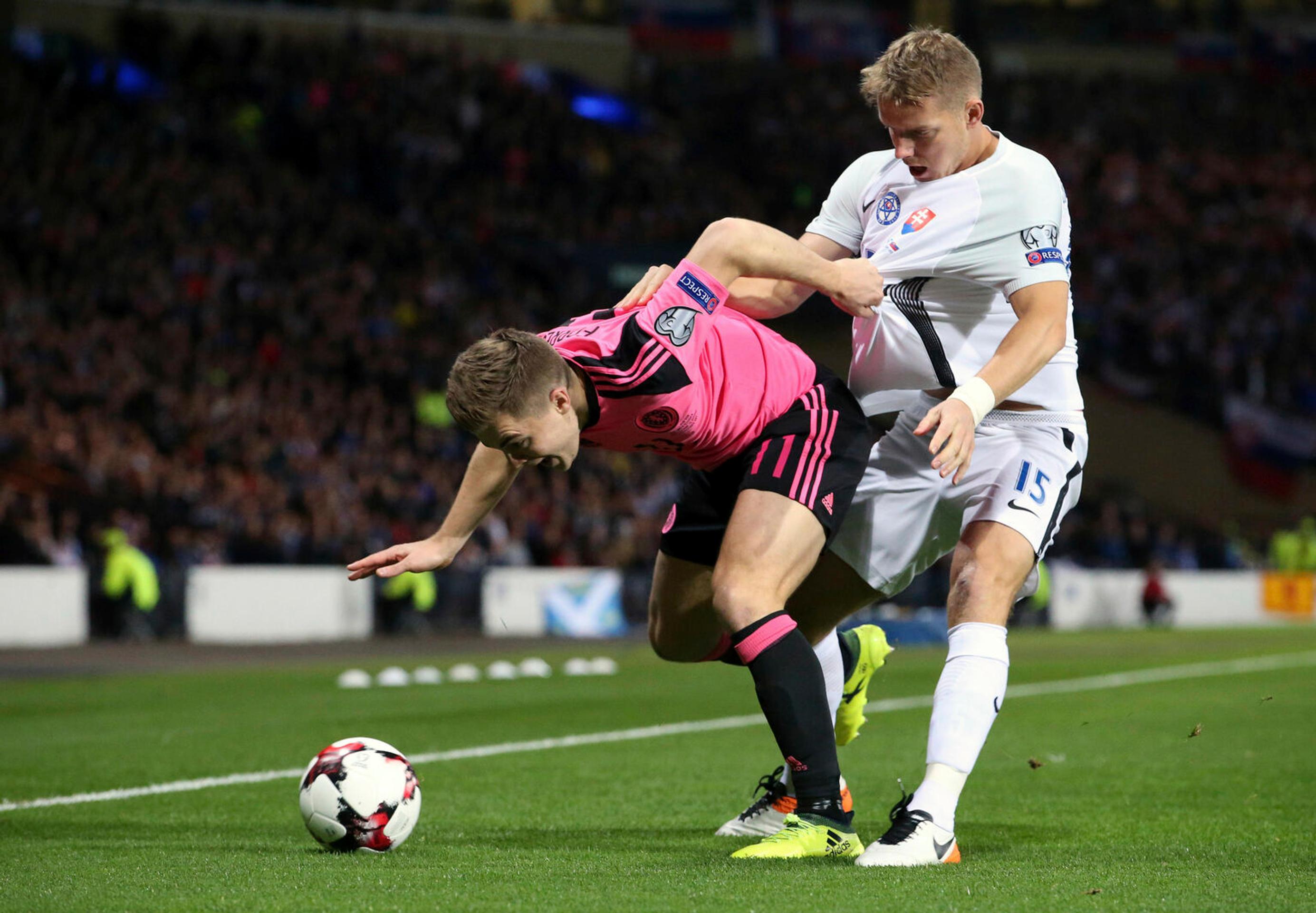 Marek Hamšík (v strede) v debate s arbitrom Miloradom Mažičom v dueli kvalifikácie MS 2018 v Škótsku. 