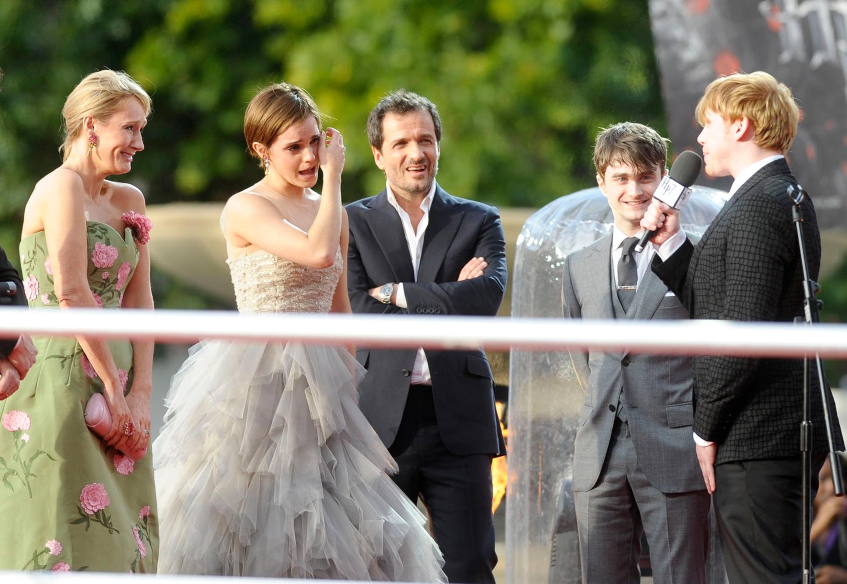 J. K. Rowlingová, Emma Watsonová a Daniel Radcliffe počúvajú príhovor Ruperta Grinta počas premiéry filmu Harry Potter a Dary smrti - 2.