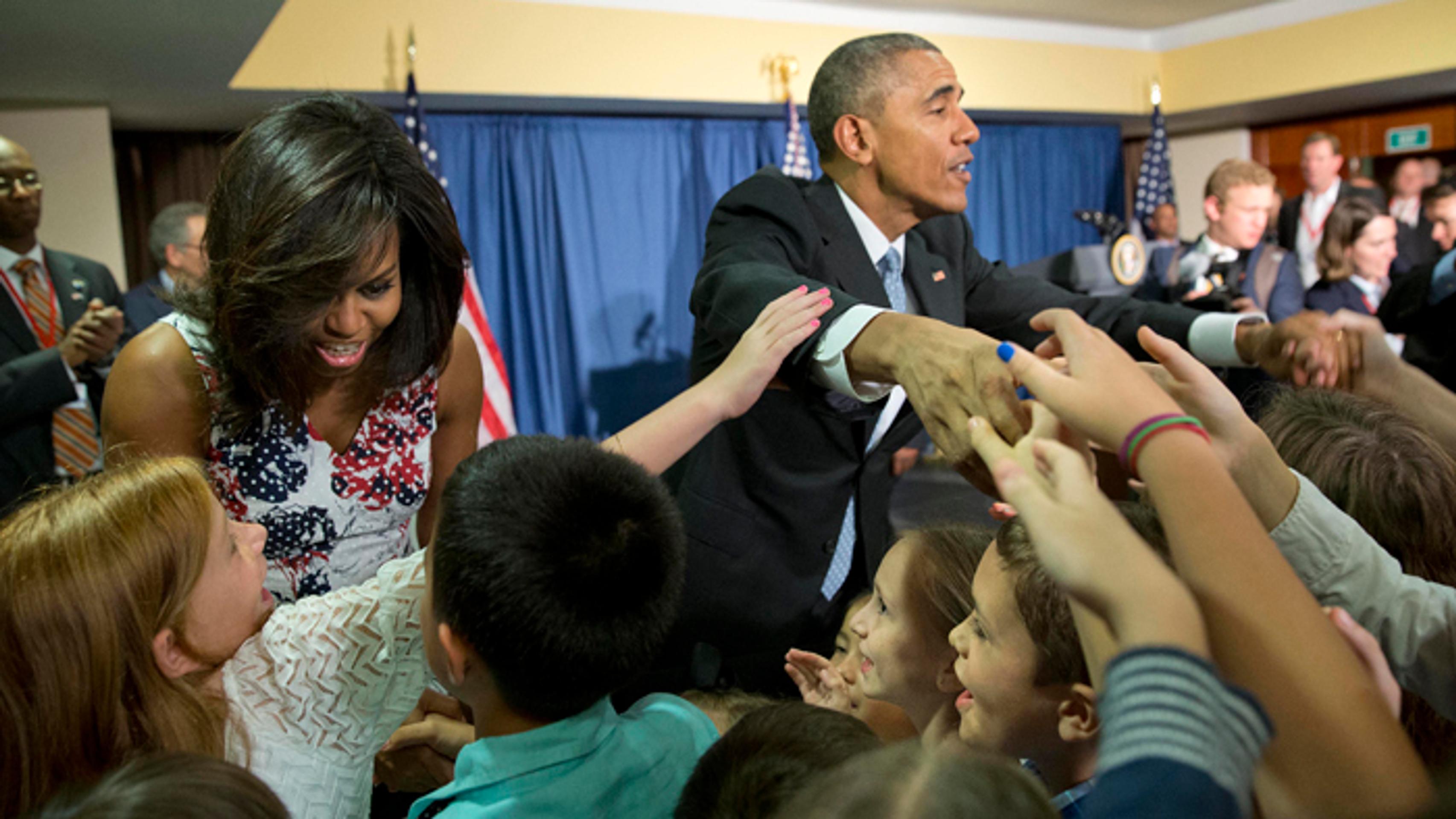 Prezident Barak Obama sa prvá dáma Michelle sa zdravia s deťmi personálu na americkej ambasáde v Havane.