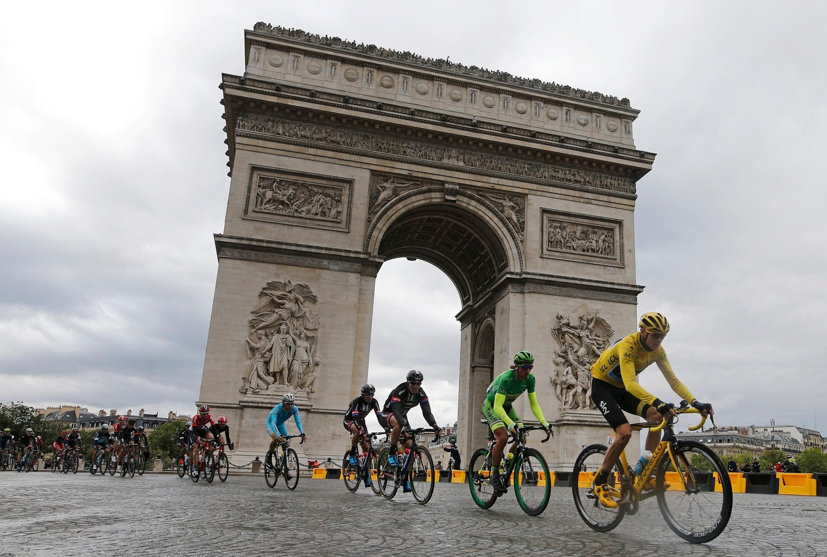 Pelotón na čele s Chrisom Froomeom a Petrom Saganom prechádza okolo Víťazného oblúka.