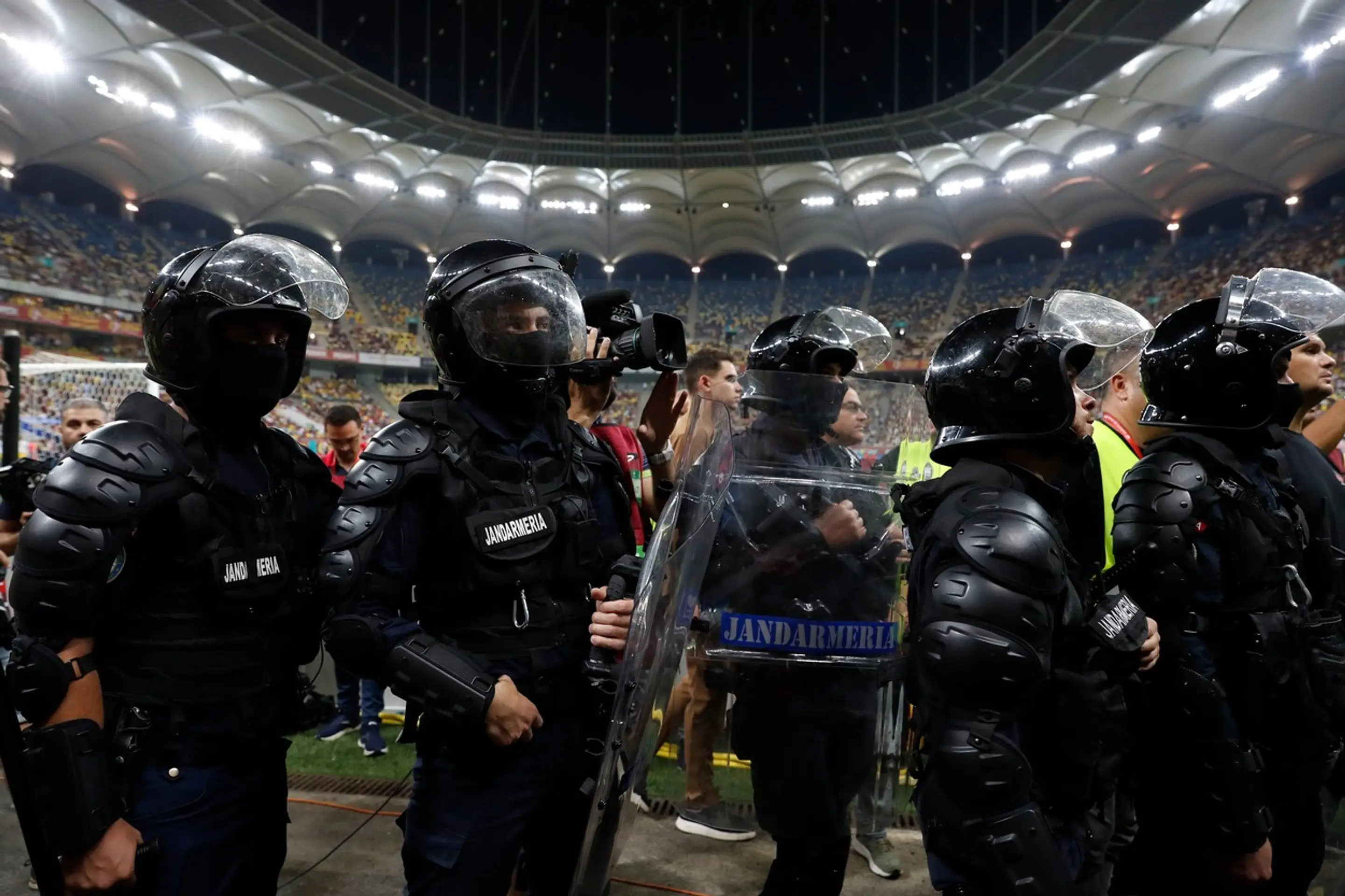 Ťažkoodenci stoja pri tribúne domácich ultras.