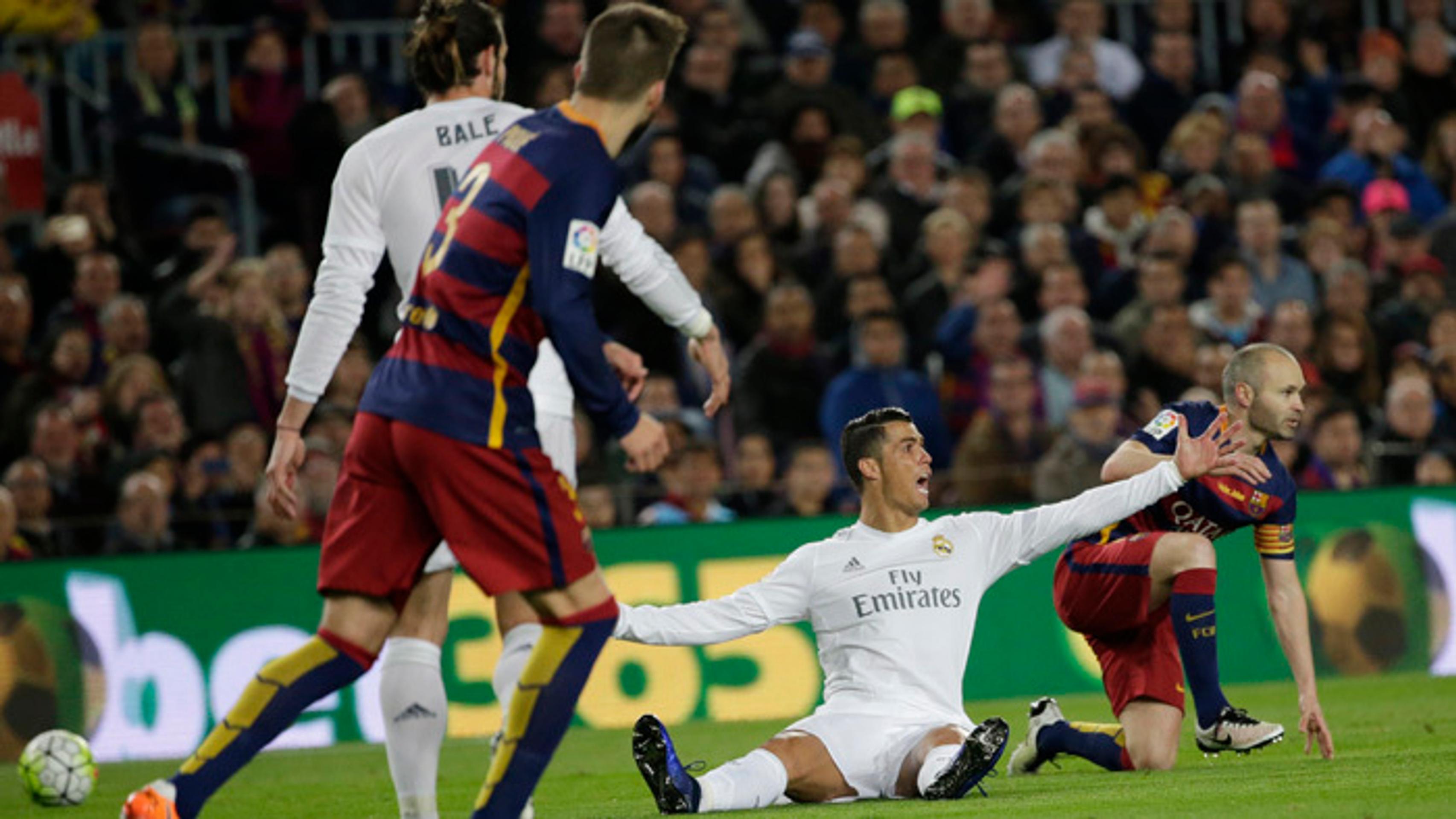 Cristiano Ronaldo gestikuluje počas El Clásico, za ním André Iniesta.