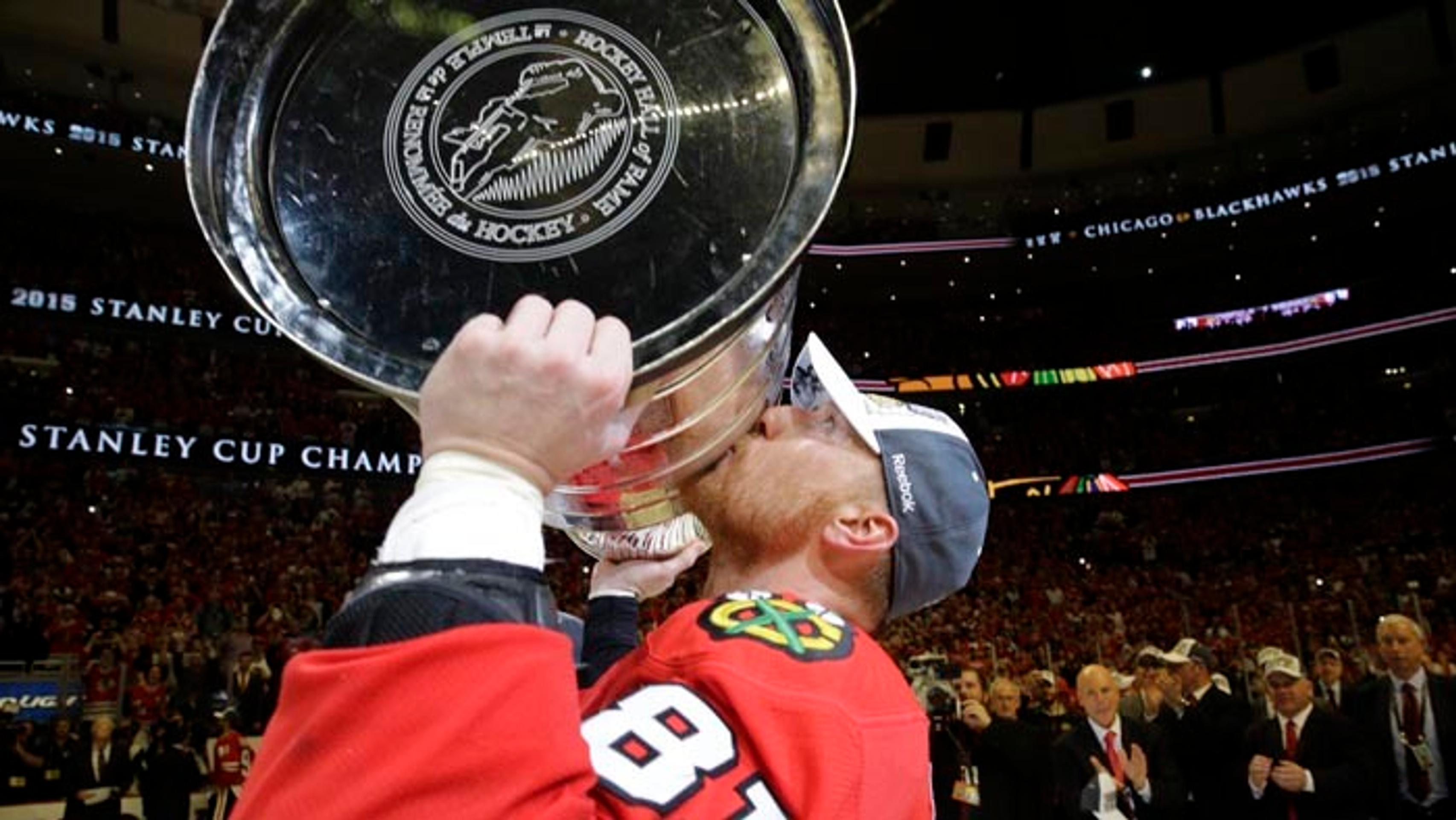 Marián Hossa zdvíha tretíkrát nad hlavu Stanleyho pohár s Chicagom Blackhawks.