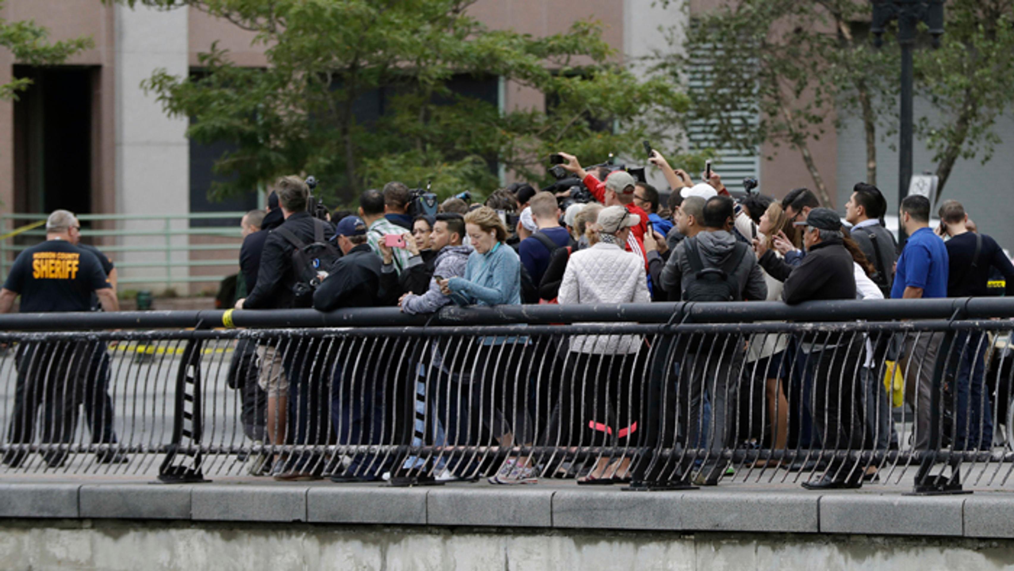 Zvedavci si fotia na mobilné telefóny miesto vykoľajenia vlaku v Hobokene v New Jersey.
