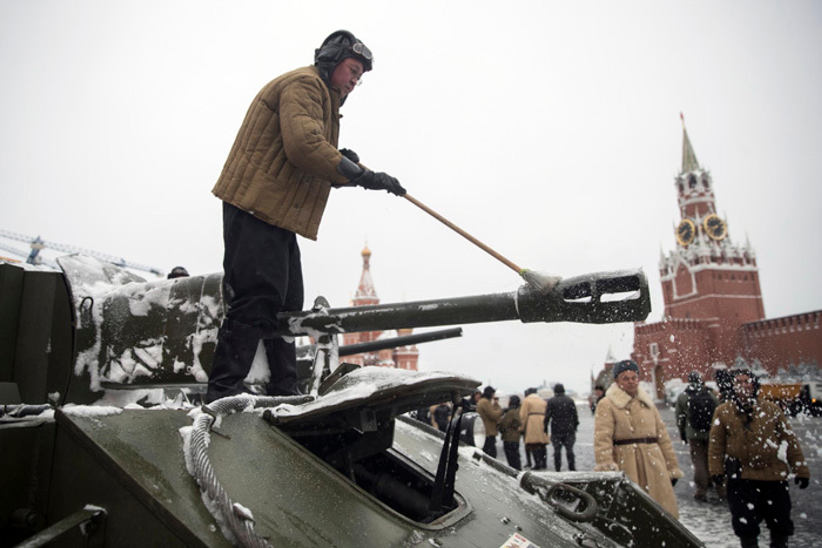 Vojak ruskej armády v dobovej uniforme odstraňuje sneh z tanku z II. svetovej vojny´. 