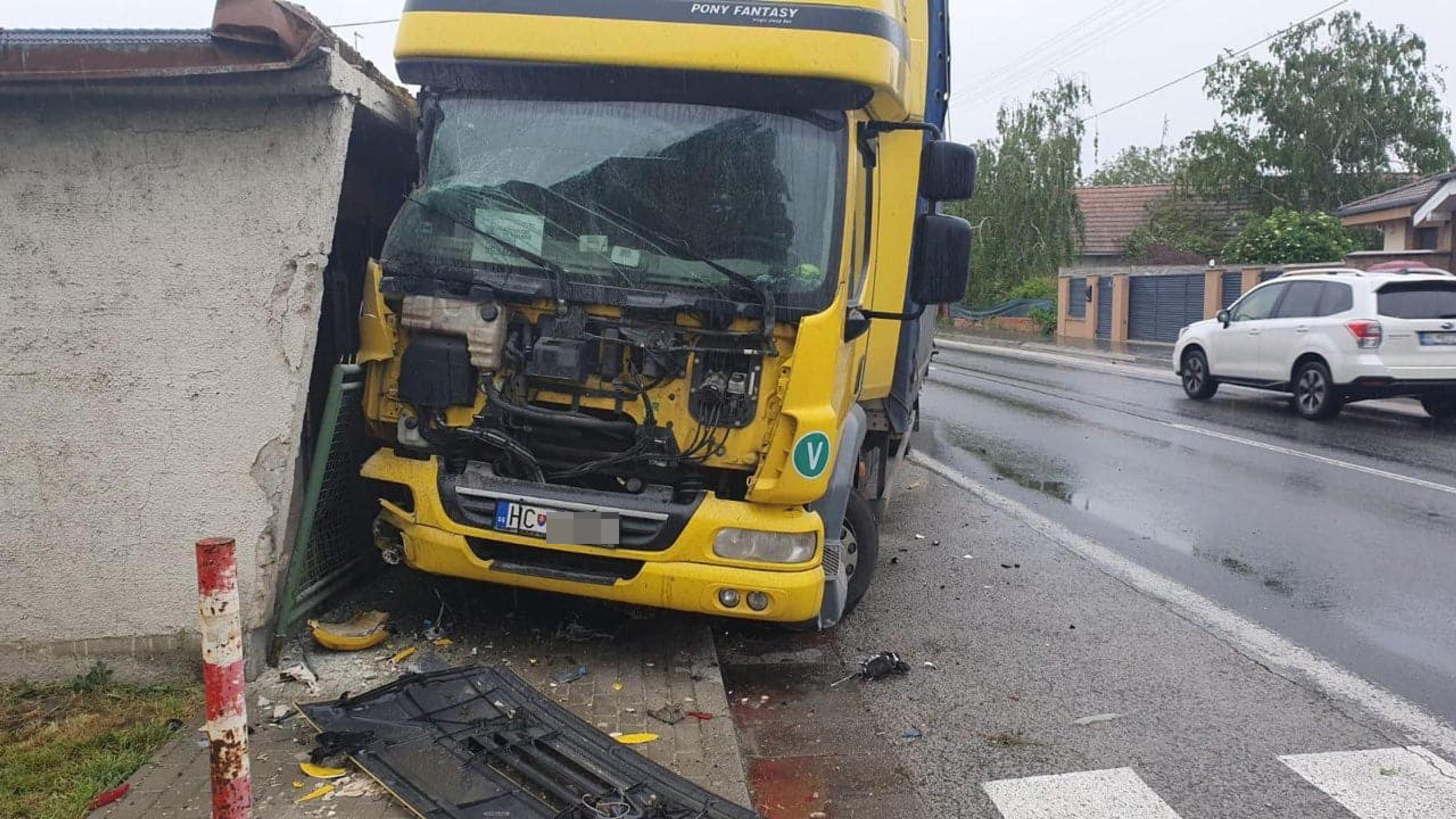 Zdemolovaná strecha auto po tom, čo v obci Horný Šúr narazil kamión do domu.