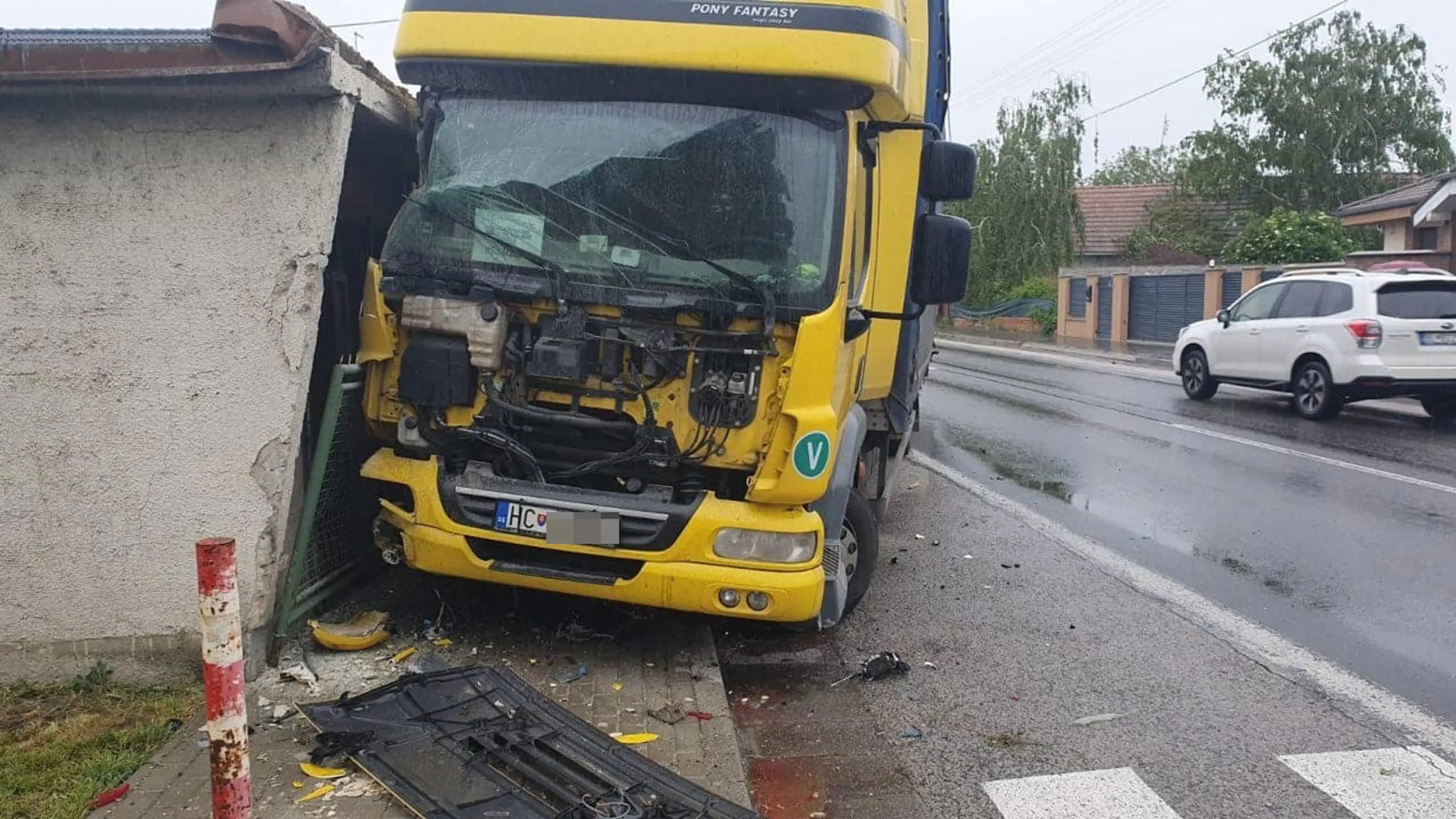 Zdemolovaná strecha auto po tom, čo v obci Horný Šúr narazil kamión do domu.
