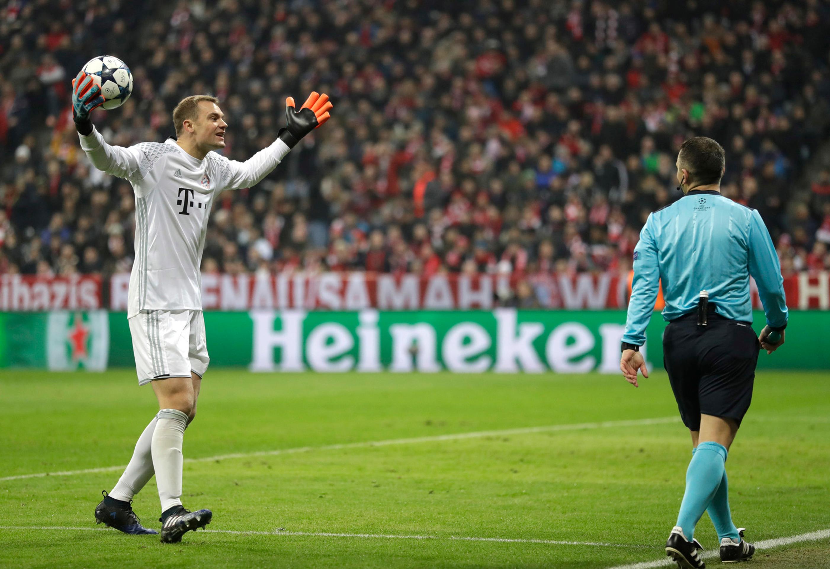 Gólman Bayernu Manuel Neuer debatuje s čiarovým arbitrom po odpískaní pokutového kopu v osemfinále LM proti Arsenalu.