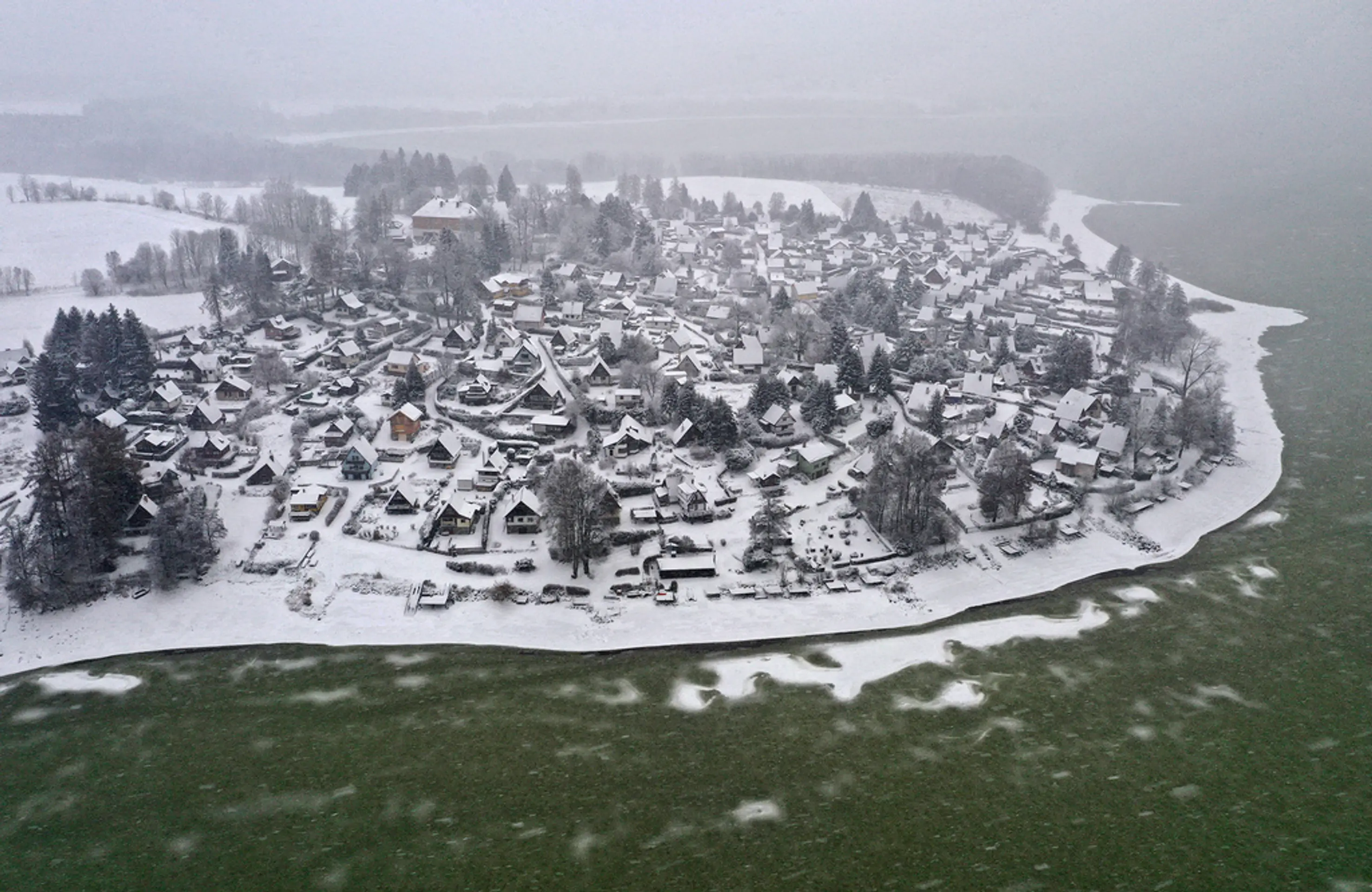 Vodnú nádrž Lipno pokryl zelený ľad zafarbený od siníc.