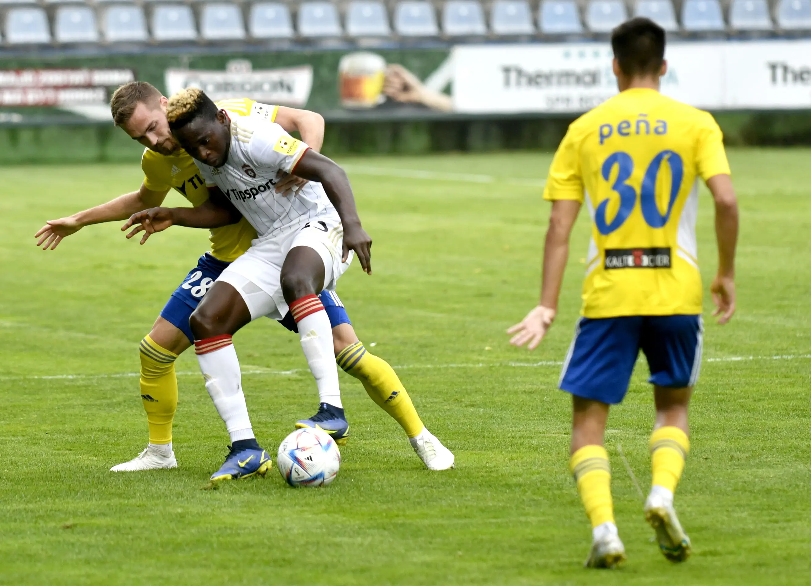 Zľava hráč MFK Zemplín Michalovce Juraj Kotula a jeho spoluhráč Brain Peňa, uprostred hráč FC Spartak Trnava Yusuf Bamidele v 5. kole Fortuna ligy.