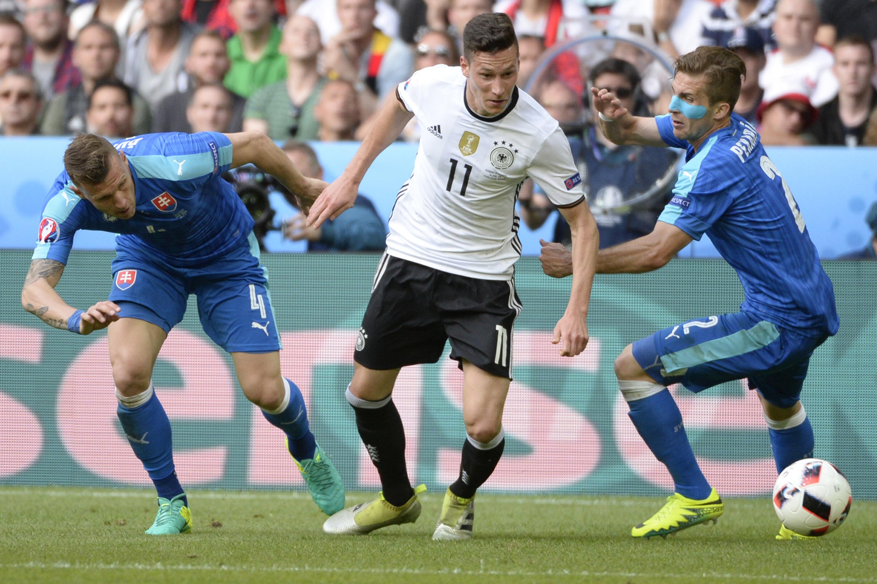 Na snímke uprostred Julian Draxler (Nemecko) a hráči Slovenska Ján Ďurica (vľavo) a Peter Pekarík na ME.