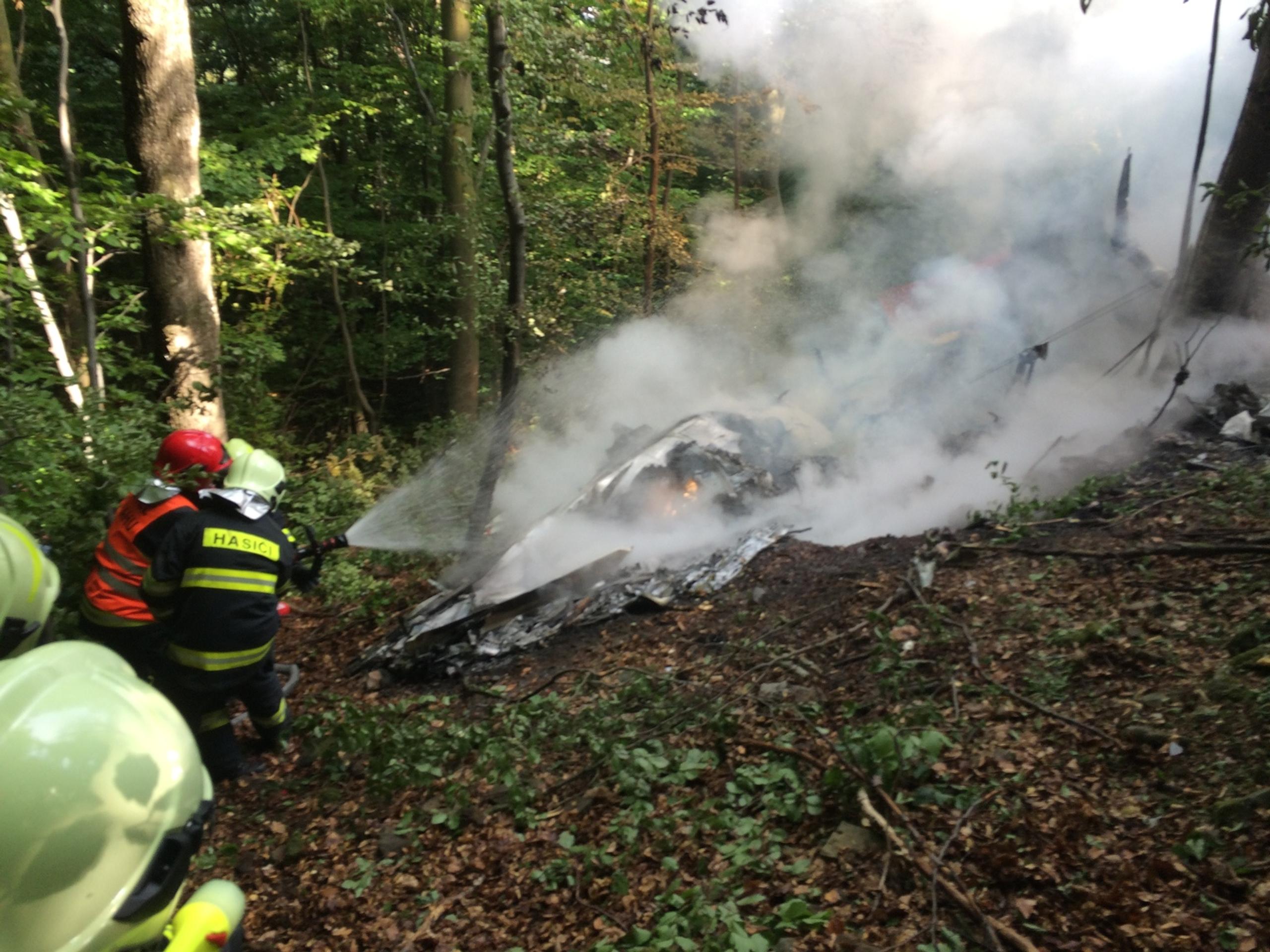 Záchranári pri vraku horiaceho lietadla nad obcou Červený Kameň.