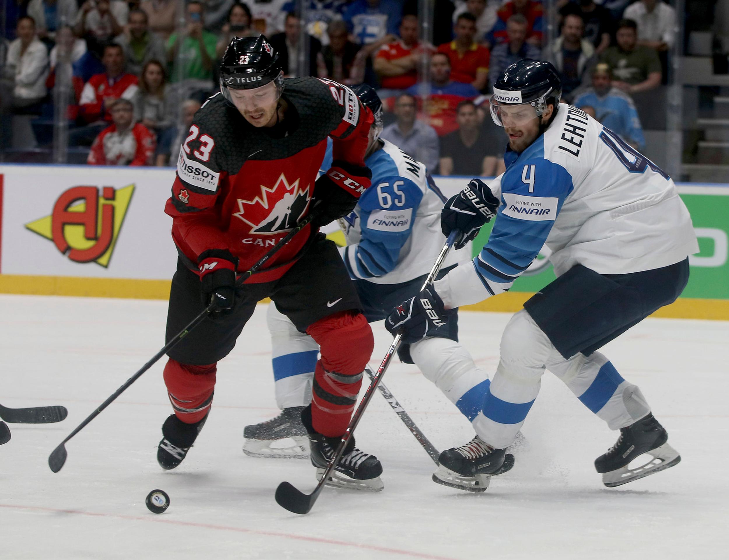 Fín Joel Kiviranta (v strede) v obkľúčení Kanaďanov vľavo Anthony Mantha a Kyle Turris vo finále MS 2019.