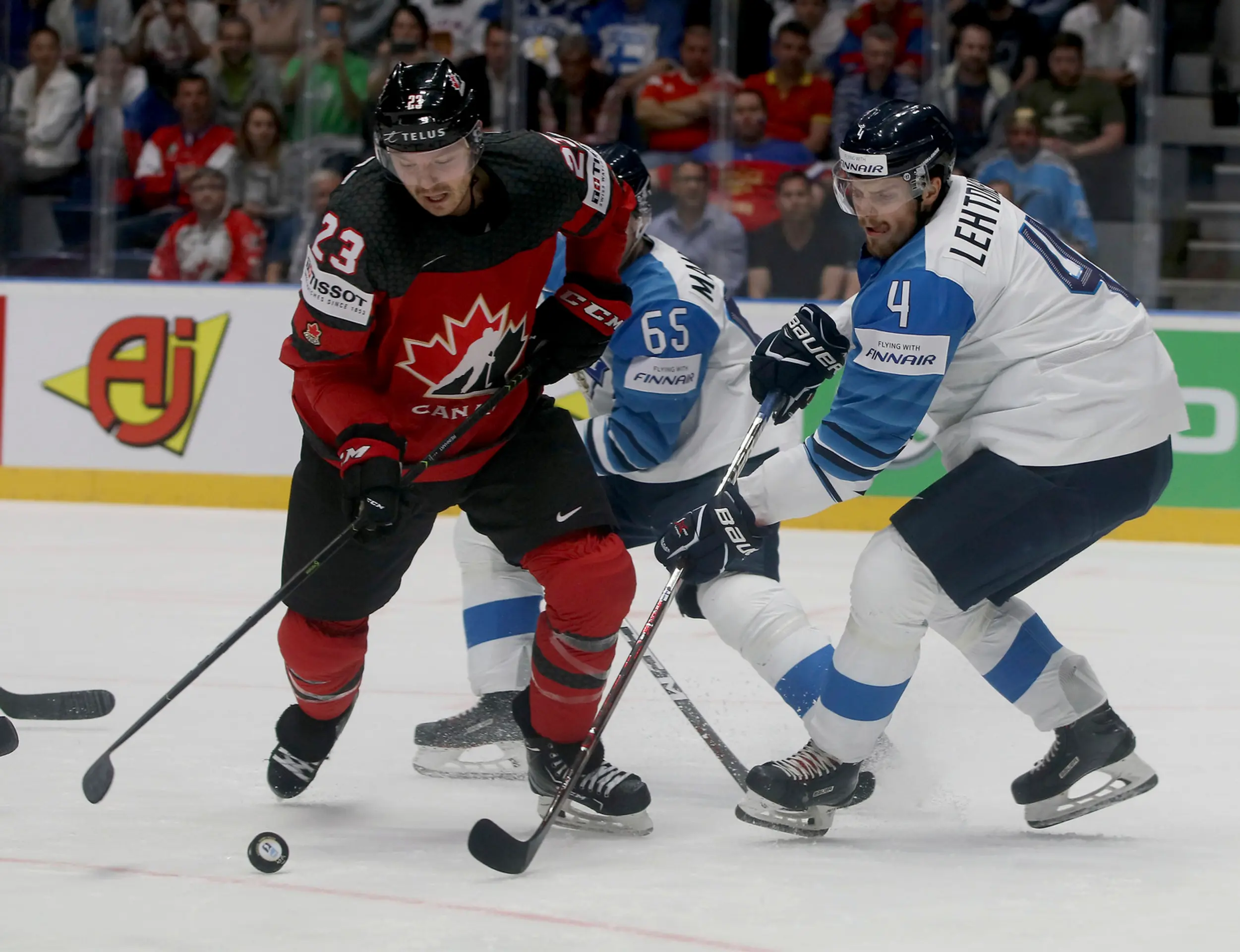 Fín Joel Kiviranta (v strede) v obkľúčení Kanaďanov vľavo Anthony Mantha a Kyle Turris vo finále MS 2019.