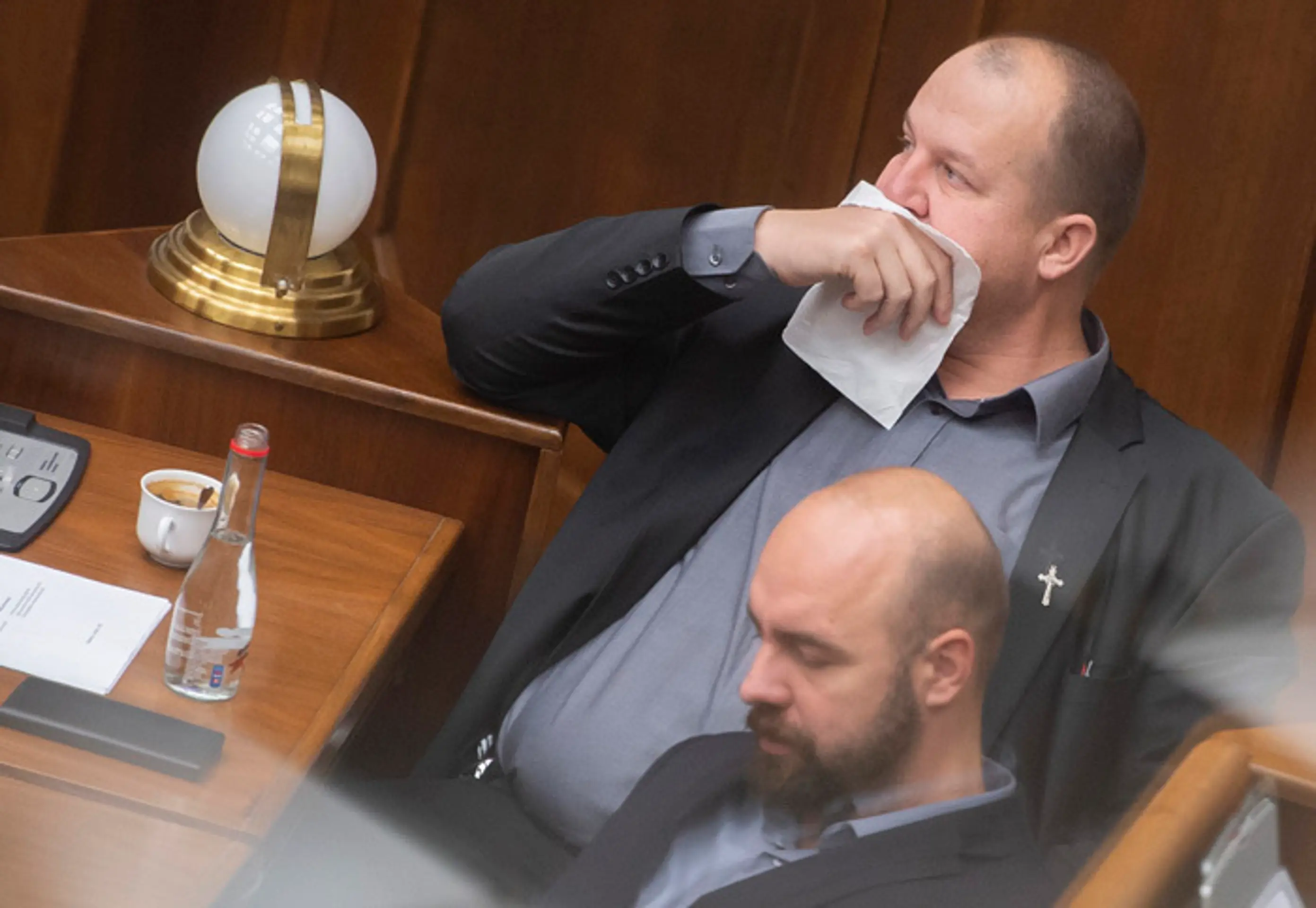 Peter Krupa si prekrýva tvár papierovou vreckovkou a dole Andrej Medvecký (obaja ĽSNS).