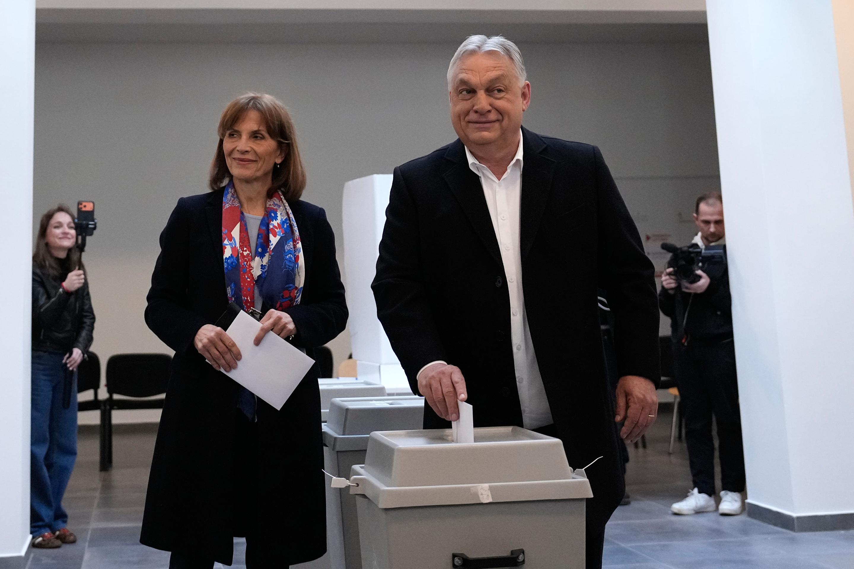 Viktor Orbán vhadzuje svoj hlasovací lístok do volebnej schránky vedľa svojej družky.
