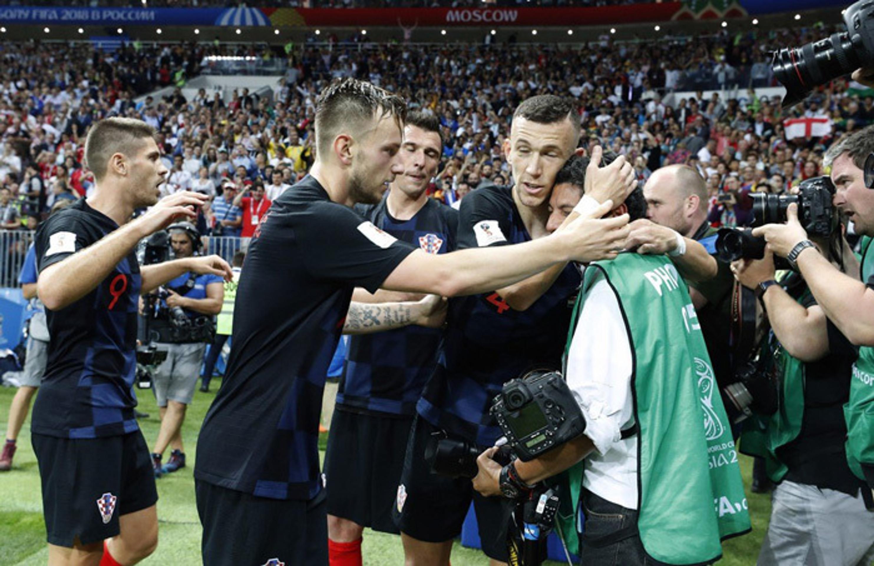 Chorvátski futbalisti utešujú fotografa, ktorého v eufórii zvalili po víťaznom góle na zem.