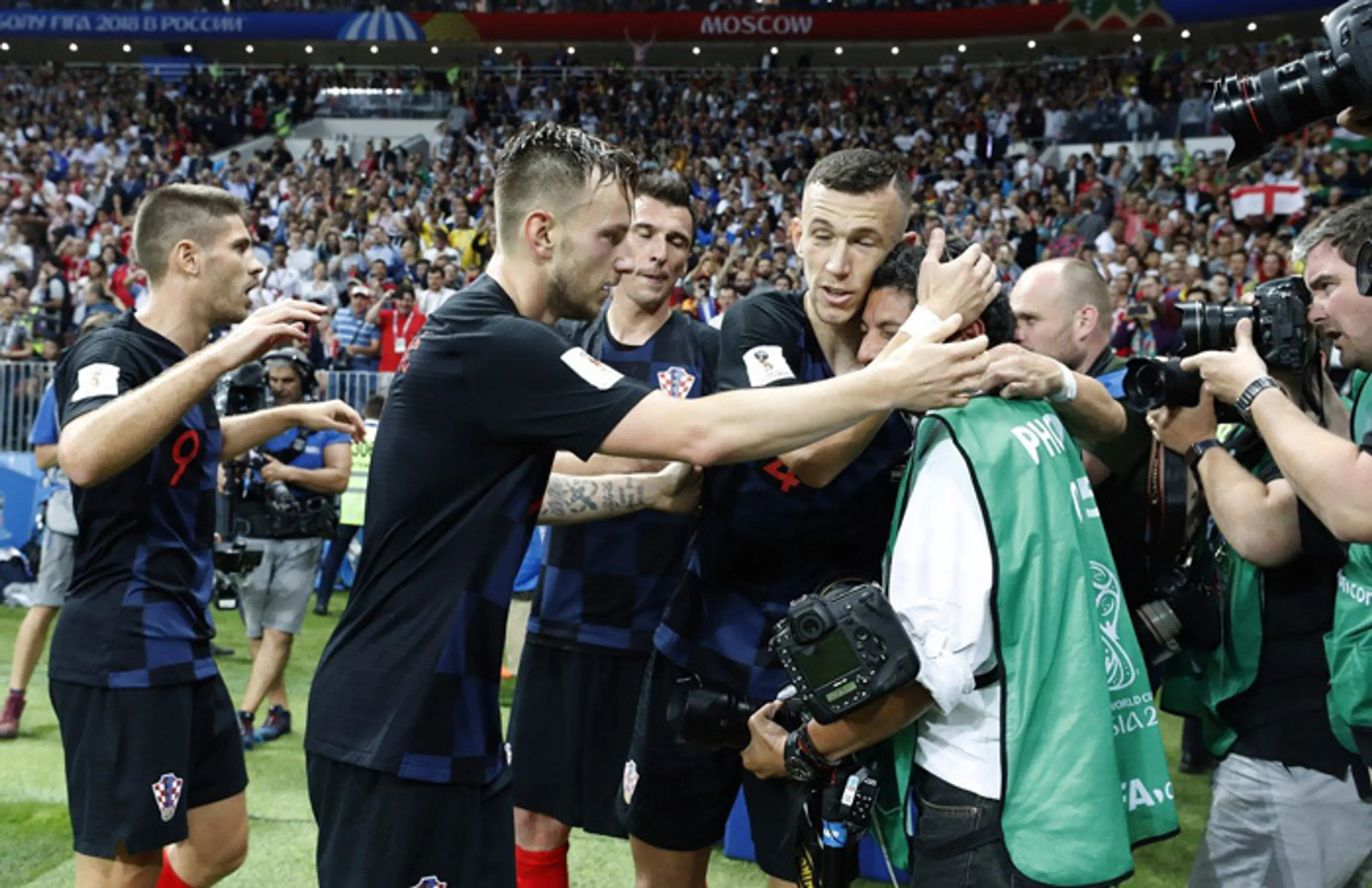 Chorvátski futbalisti utešujú fotografa, ktorého v eufórii zvalili po víťaznom góle na zem.
