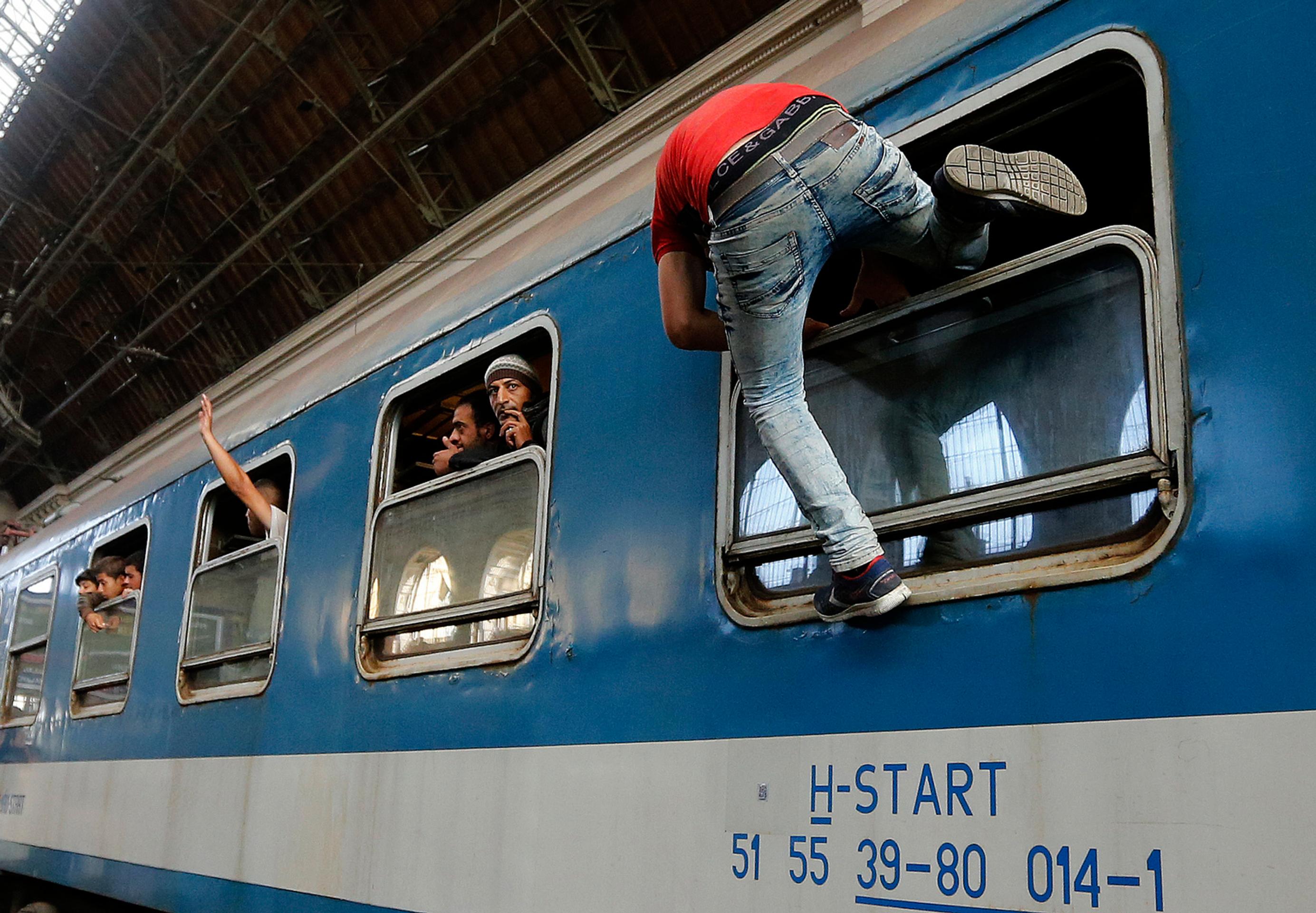 Migranti sa snažia nastúpiť do vlaku v Budapešti.