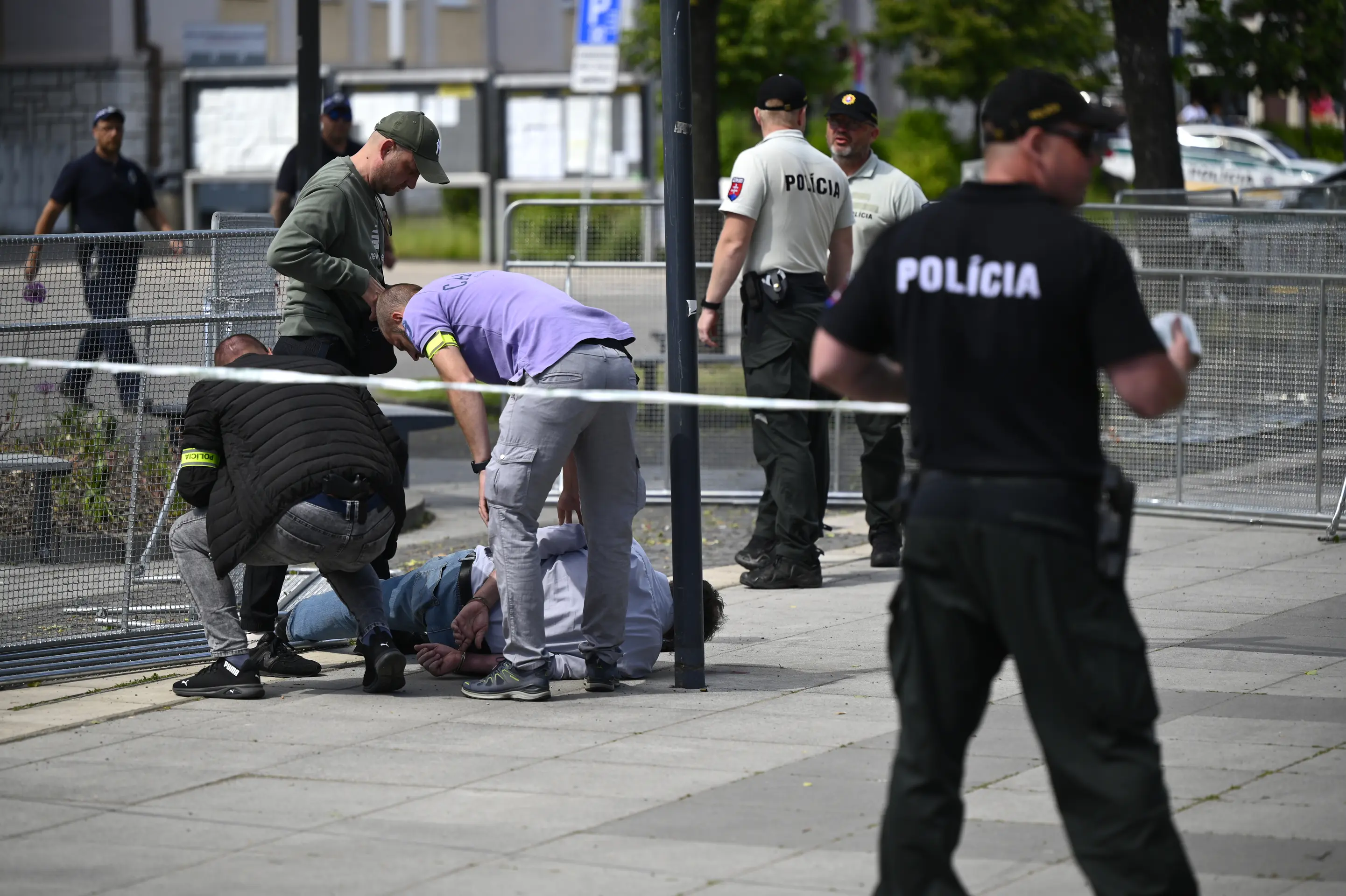 Na snímke policajti zatýkajú muža po streľbe na predsedu vlády Roberta Fica na výjazdovom rokovaní vlády v Handlovej