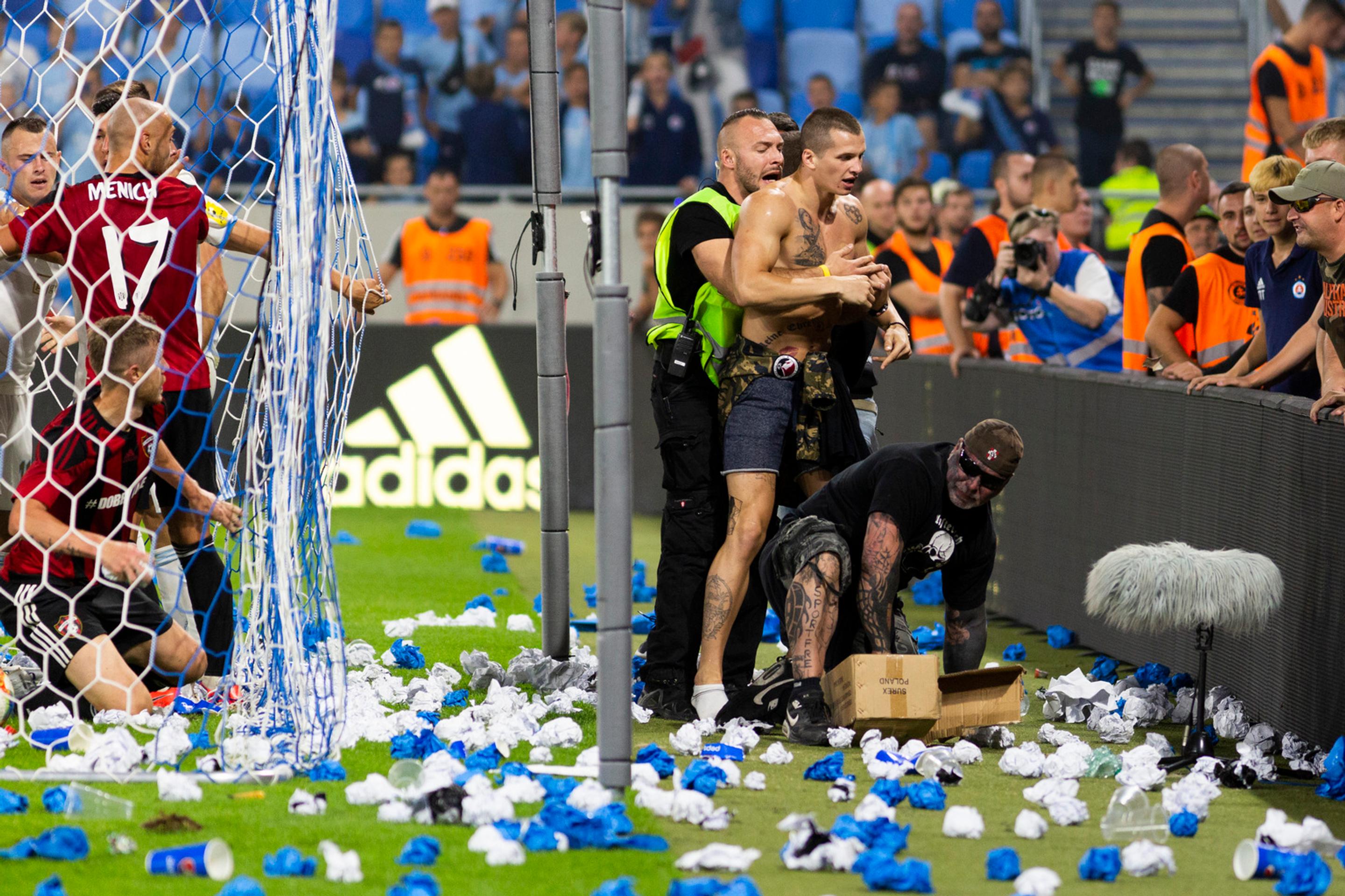 Na snímke vpravo jeden z fanúšikov Slovana vbehol na ihrisko a pridal sa k roztržke hráčov oboch mužstiev.