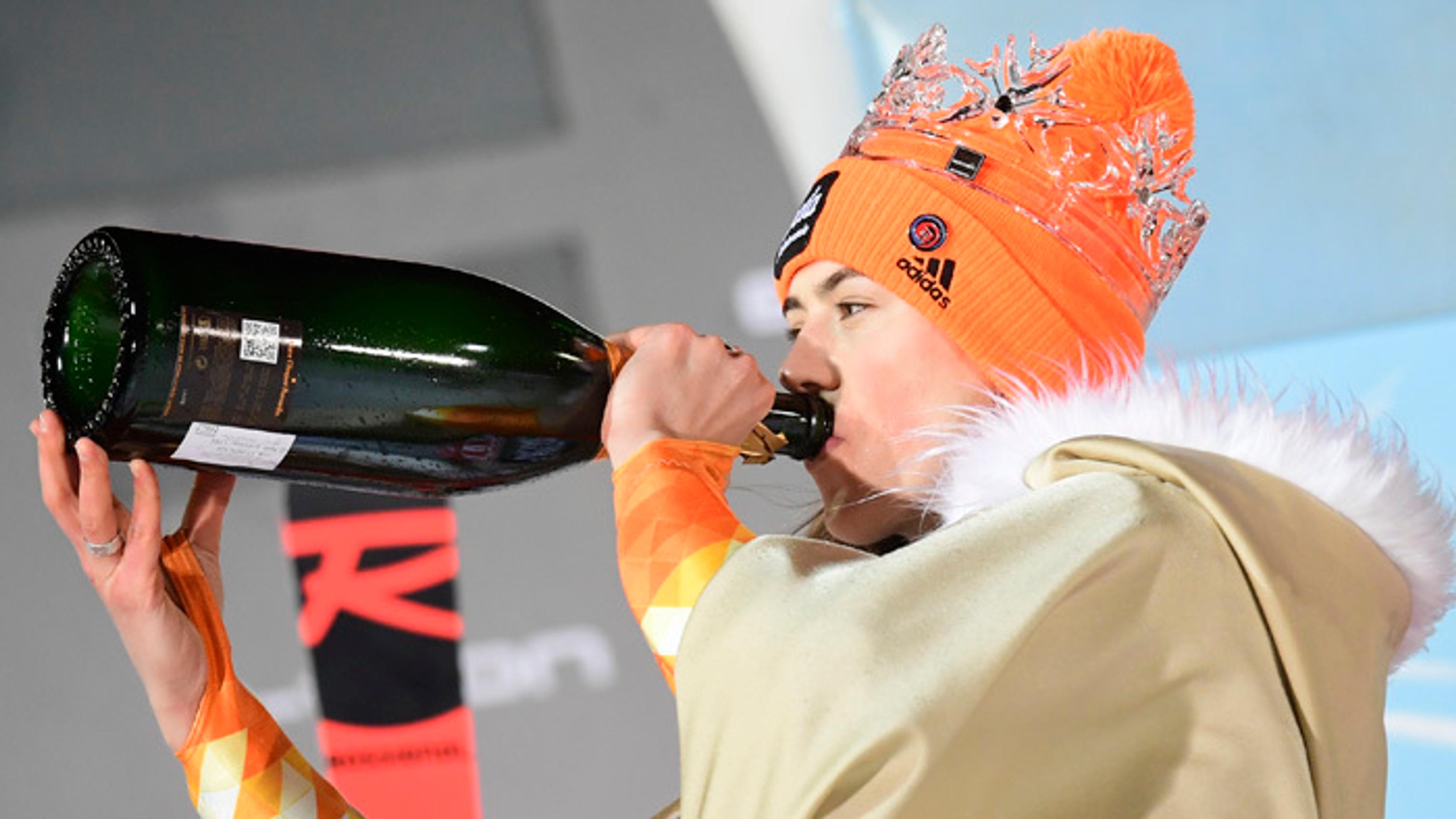 etra Vlhová pije šampanské na pódiu po triumfe v Zahrebe.