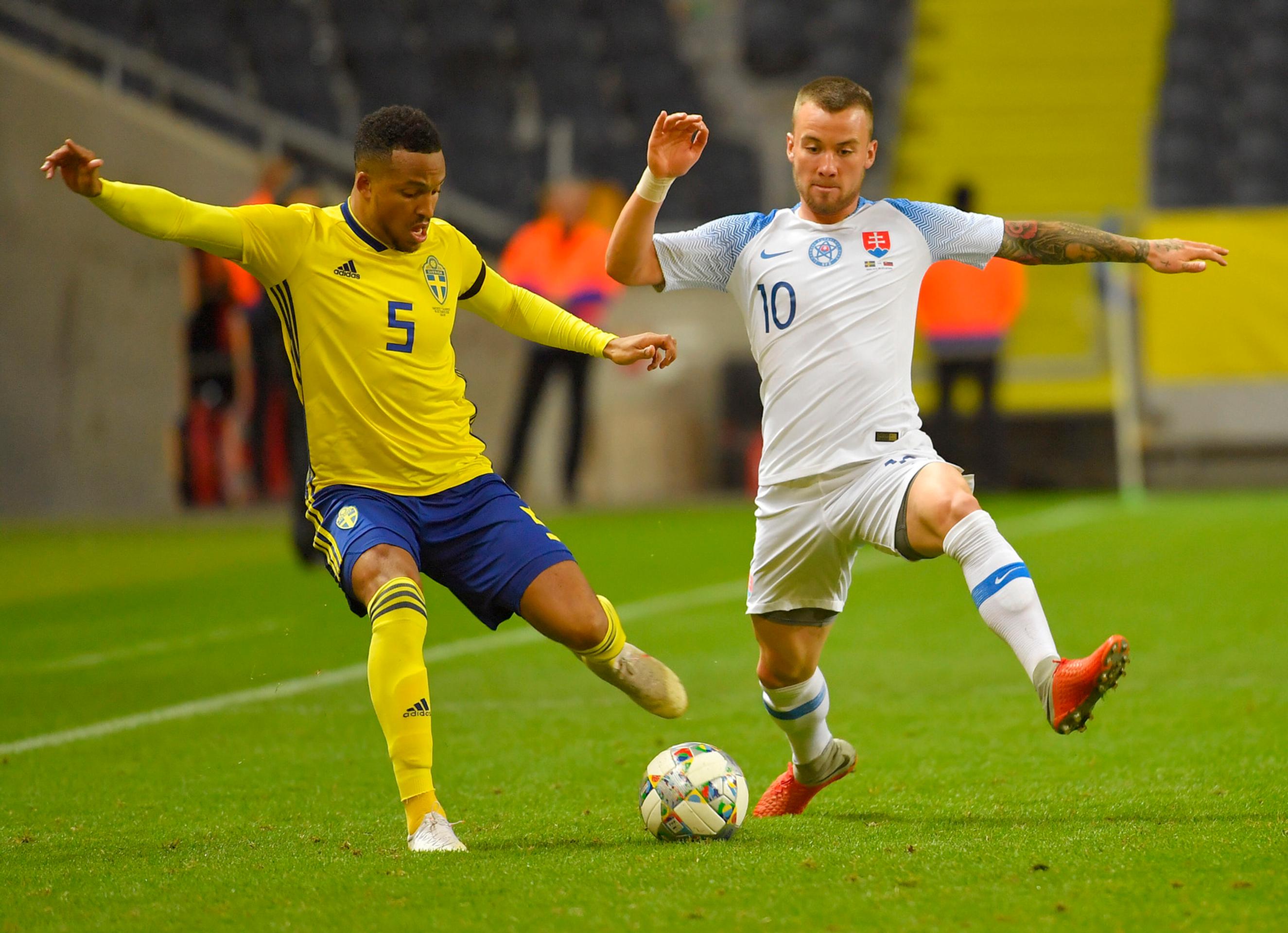 Albert Rusnák (vpravo) bojuje o loptu so Švédom Martinom Olssonom v medzištátnom zápase.