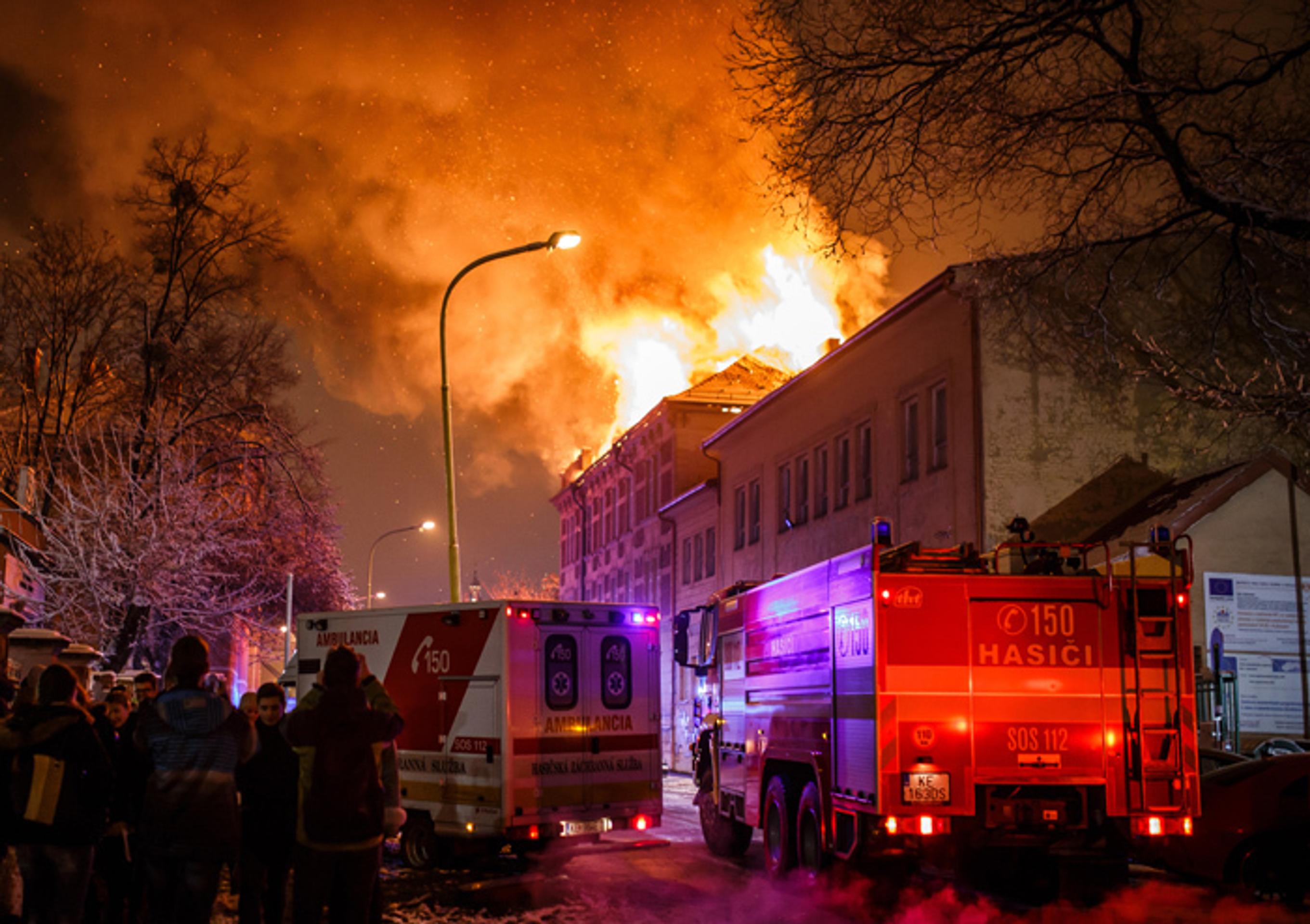 Plamene šľahajú zo strechy budovy Univerzity Pavla Jozefa Šafárika počas požiaru v Košiciach.
