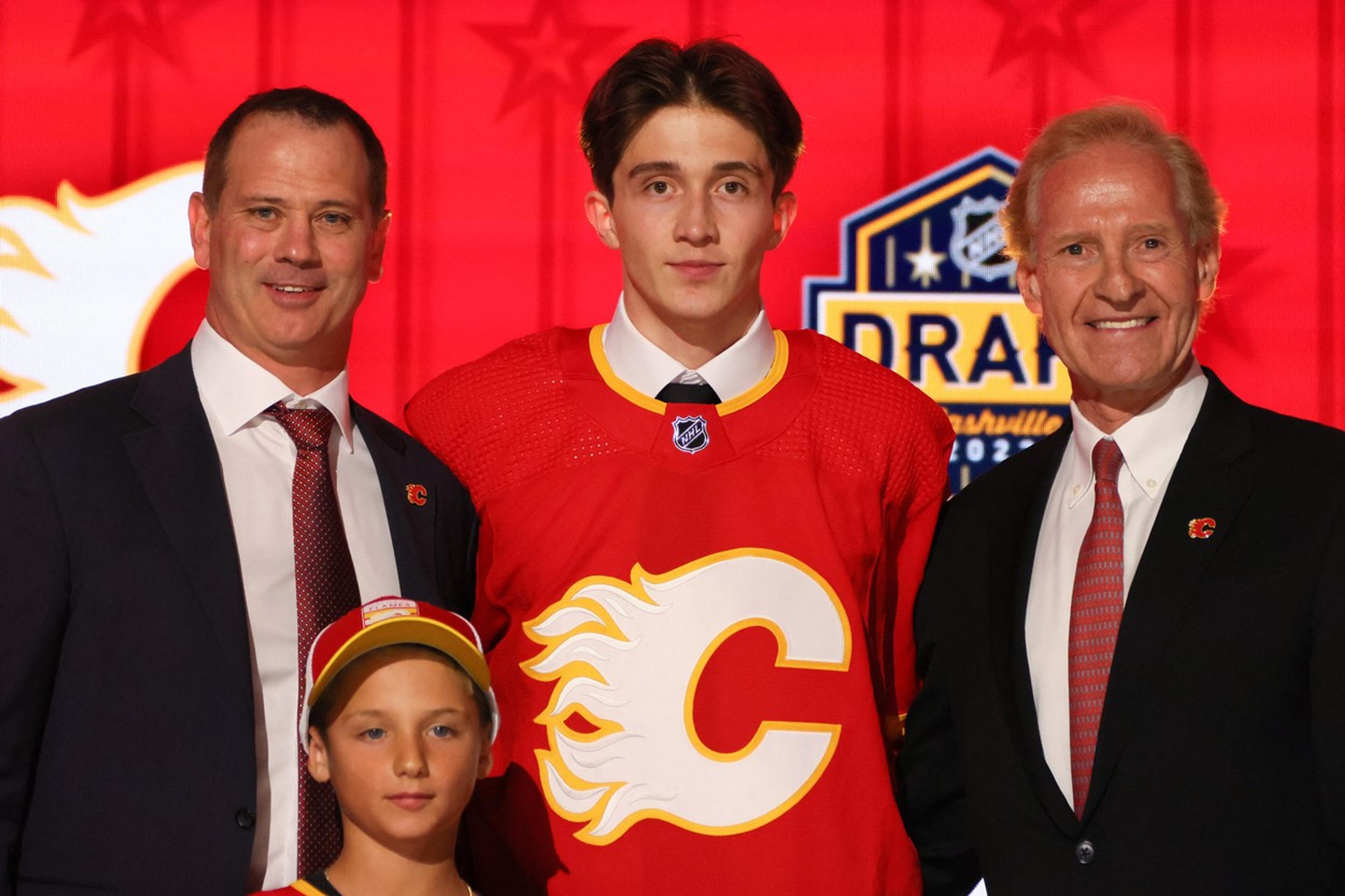 Samuel Honzek pózuje v drese Calgary na NHL drafte 2023.