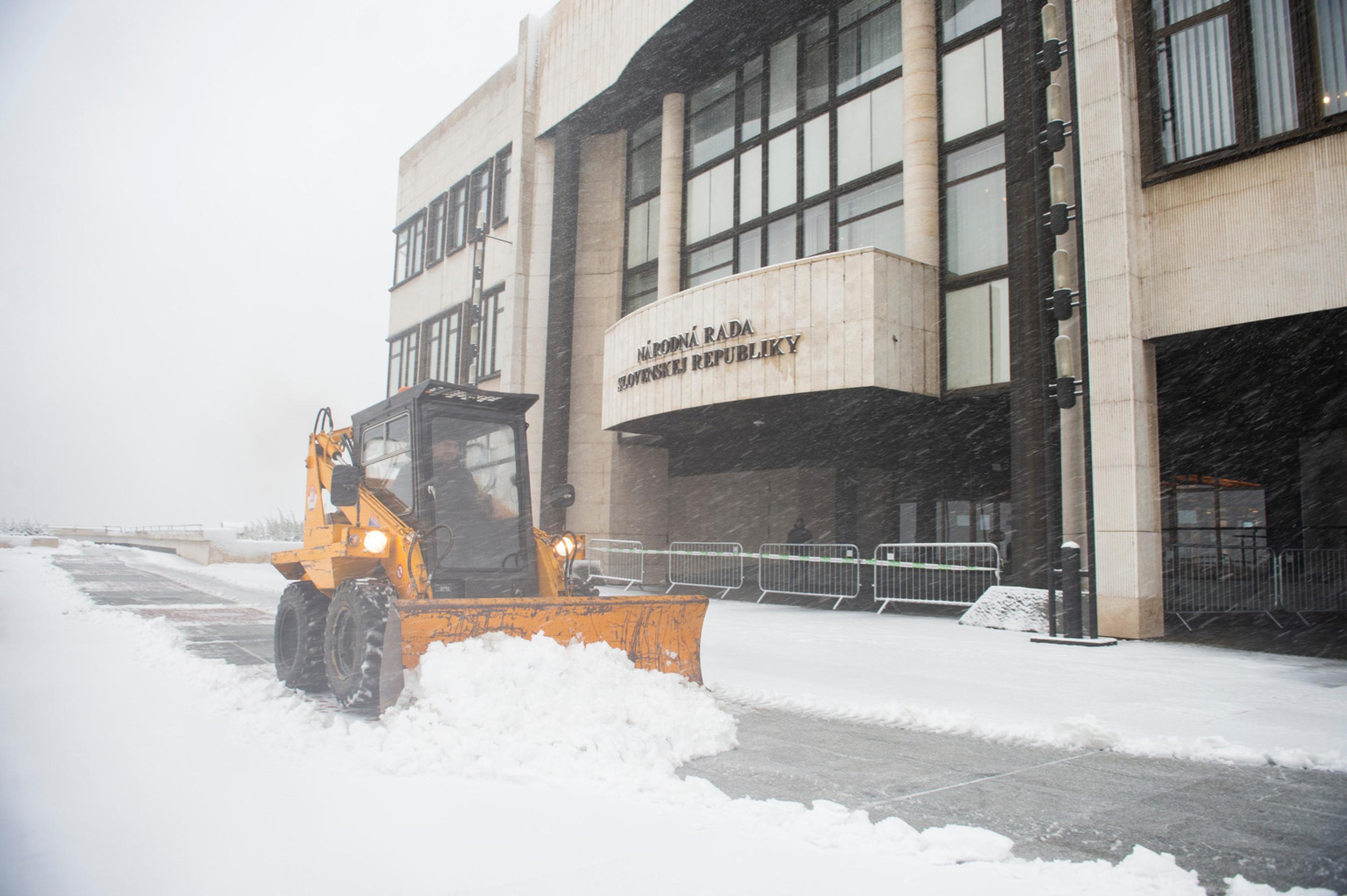 Traktor so snežným pluhom pred parlamentom.