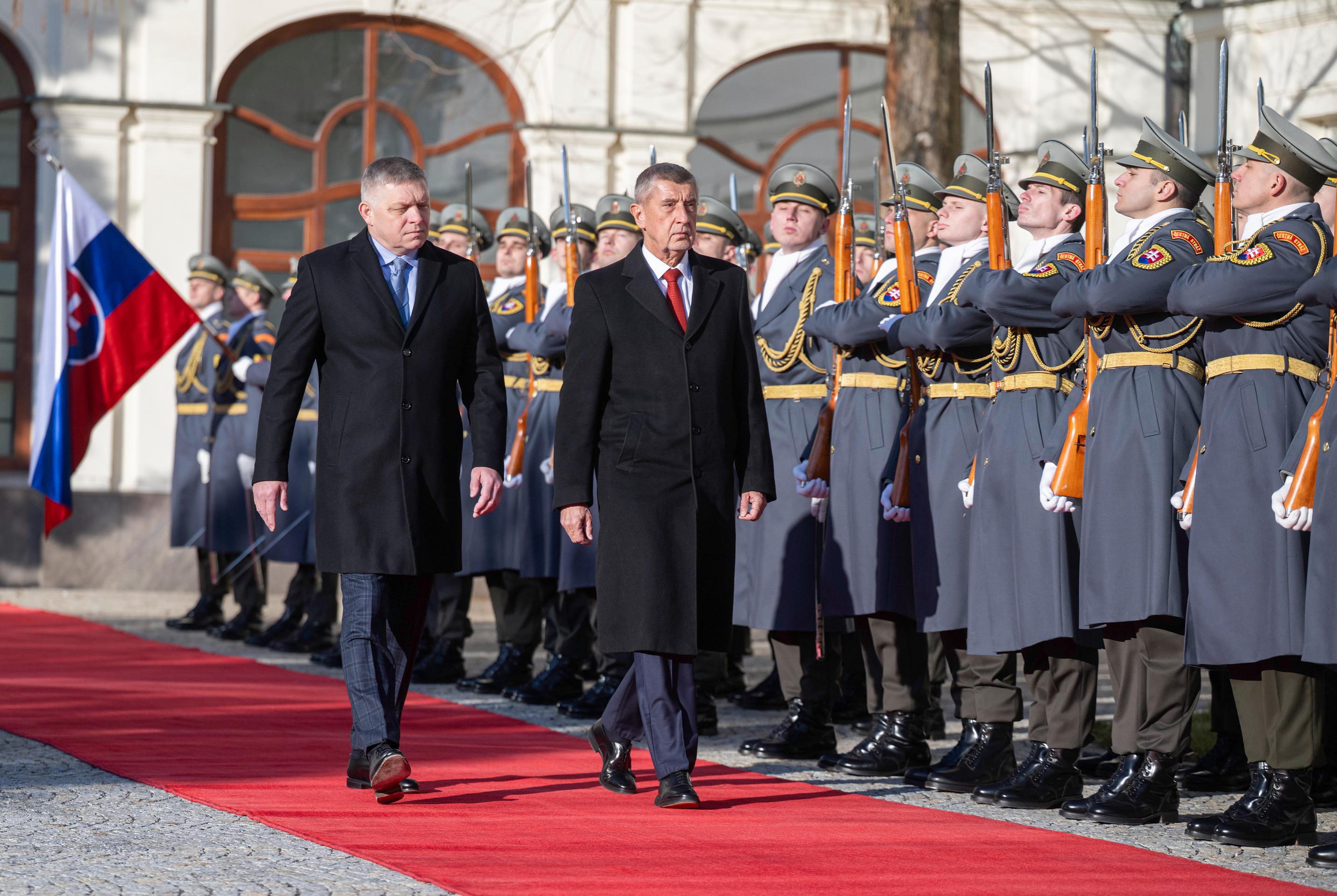 Slovenský premiér Robert Fico (vľavo) a český premiér Andrej Babiš (vpravo) kráčajú po červenom koberci počas uvítacieho ceremoniálu v Bratislave.