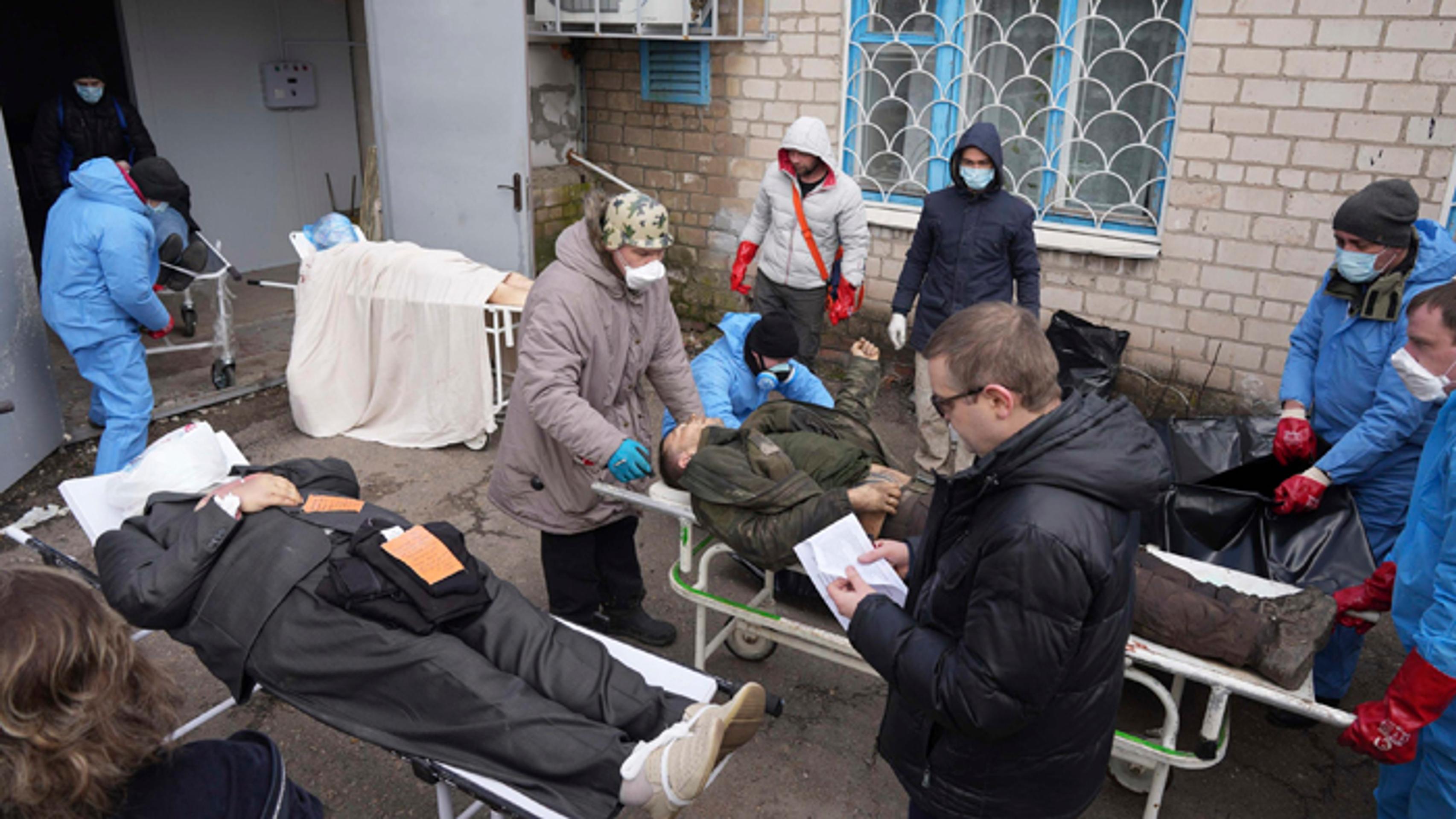 Telá obetí, ktoré budú dávať do vriec a ukladať do masového hrobu  v Mariupole.