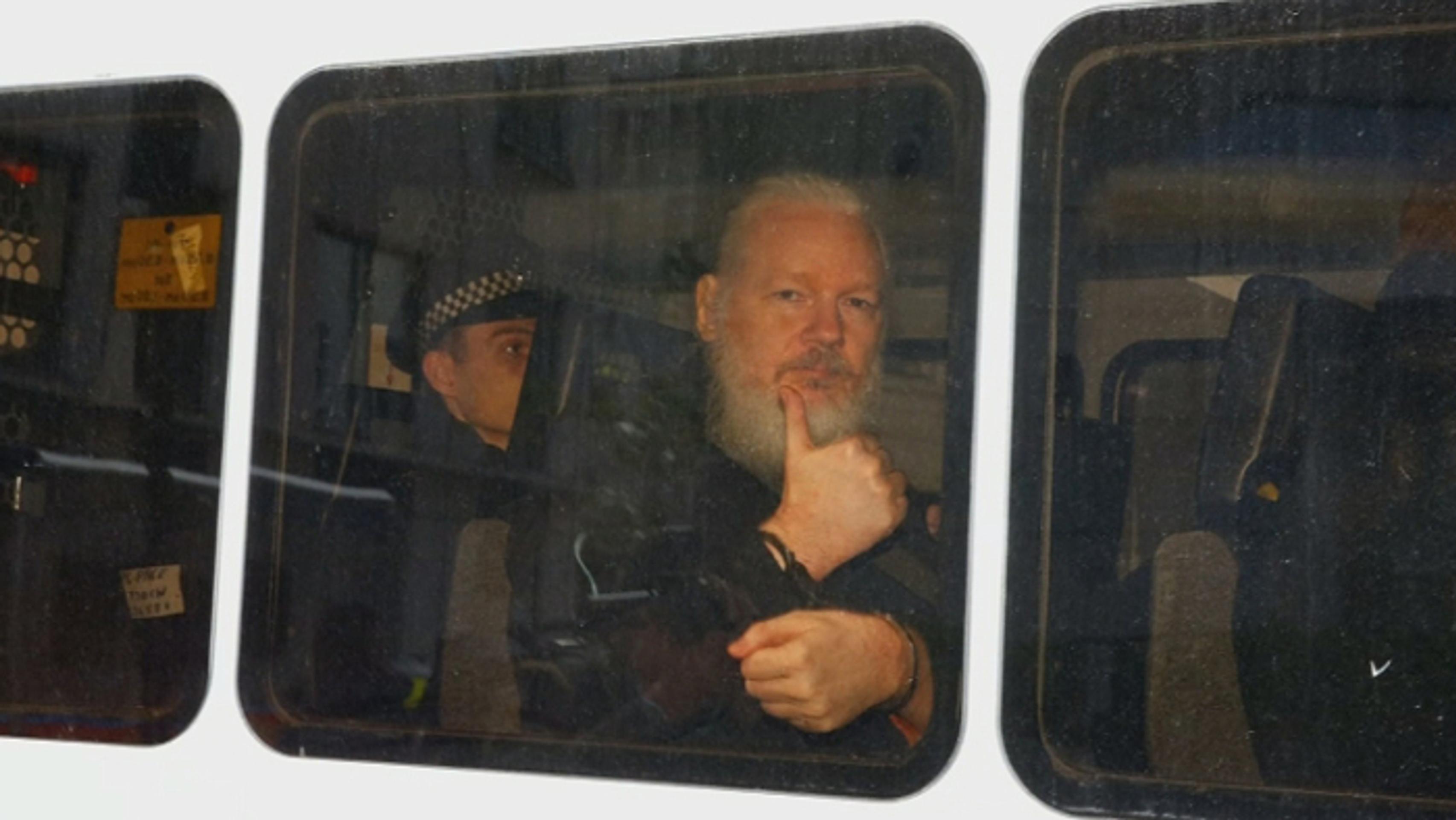 Julian Assange gestikuluje počas príchodu na súd po zatknutí v Londýne.