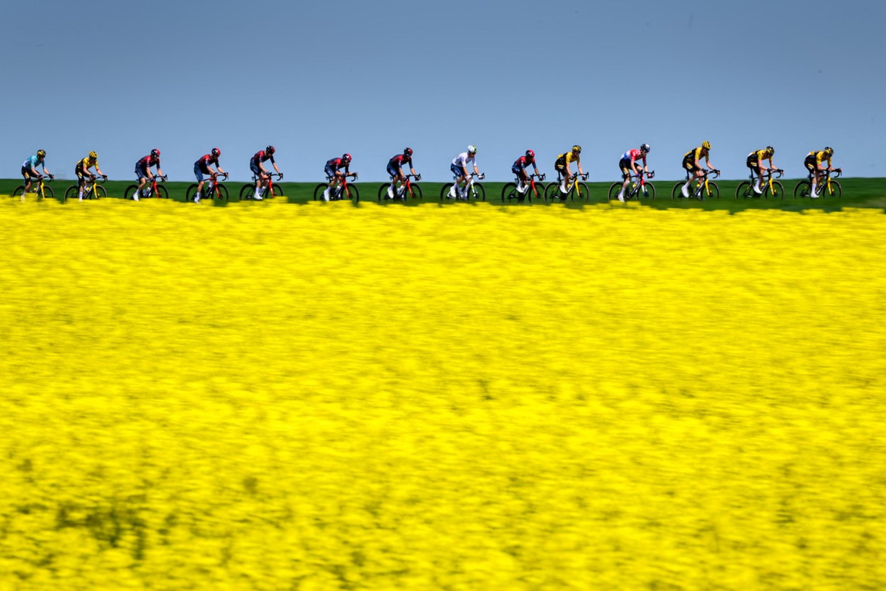 Skupina jazdcov prechádza okolo švajčiarskej dediny Echallens počas 4. etapy cyklistických pretekov Tour de Romandie.