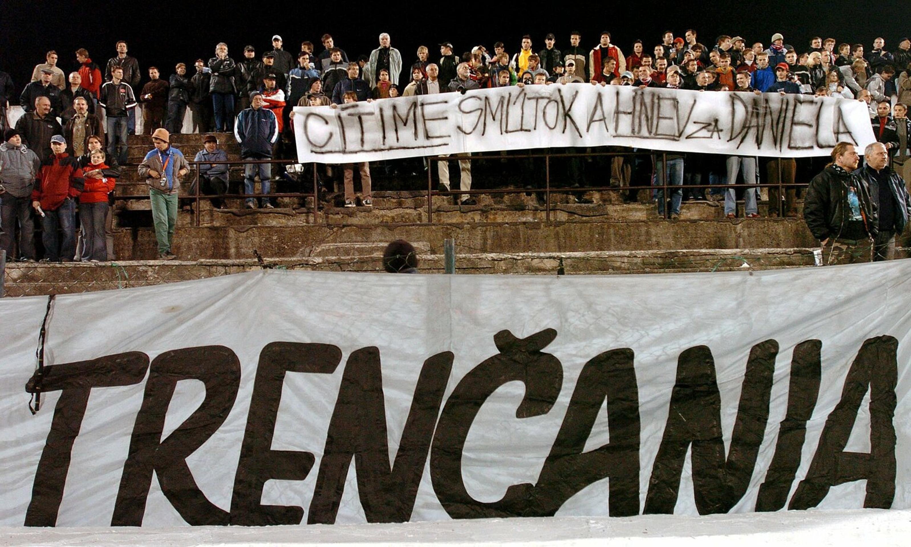 Horiace sviečky, transparent s nápisom "Cítime smútok a hnev za Daniela"