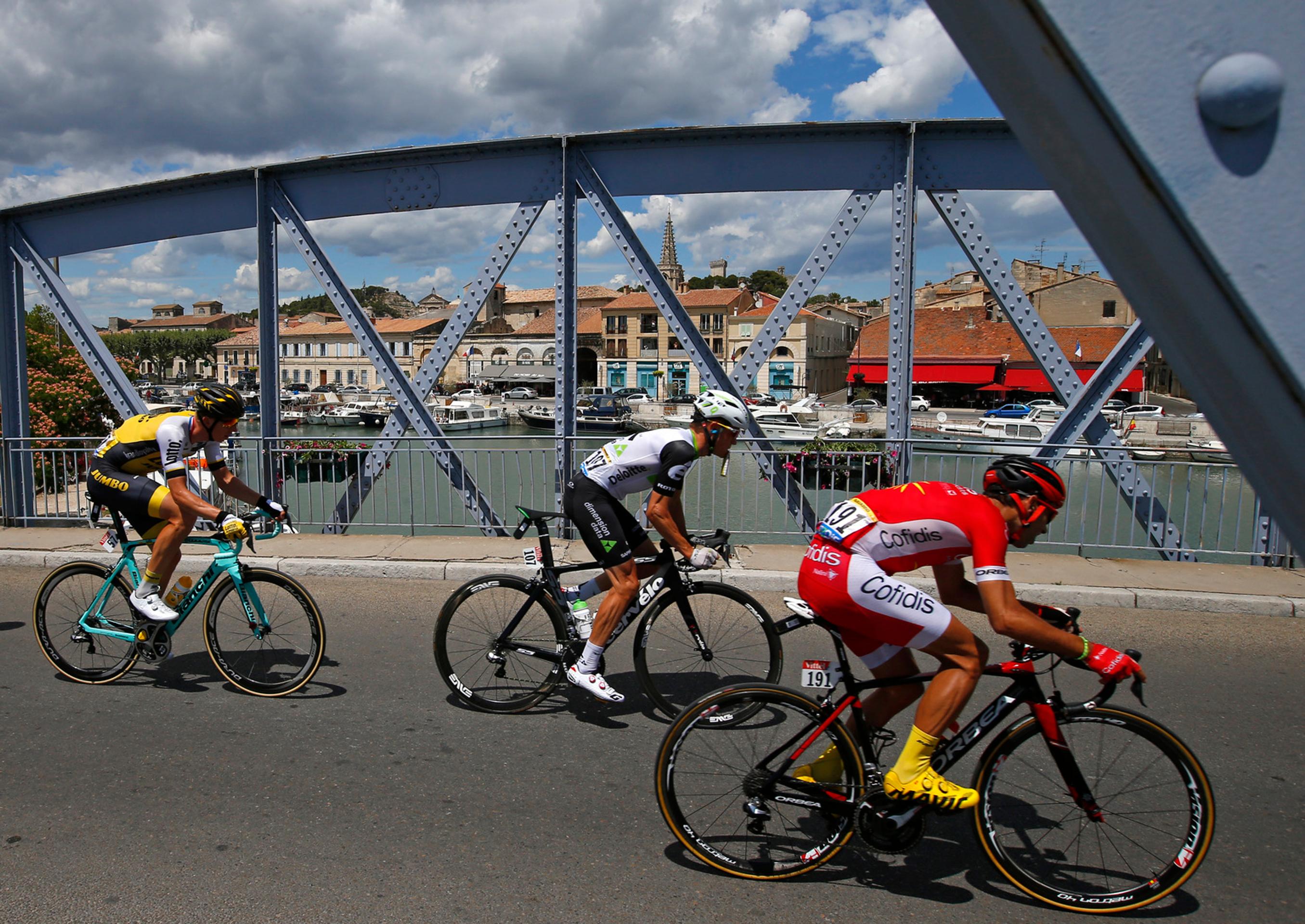 Cyklisti prechádzajú cez most poča 12. etapy Tour de France