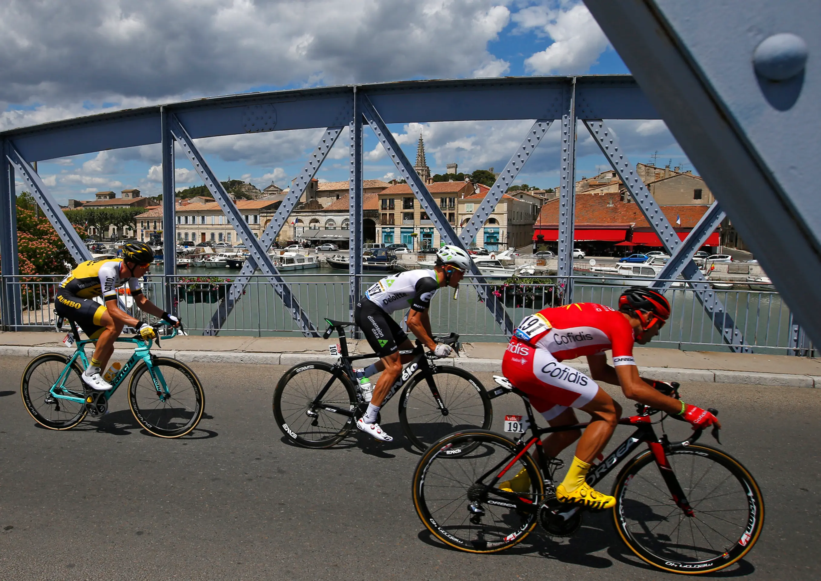 Cyklisti prechádzajú cez most poča 12. etapy Tour de France
