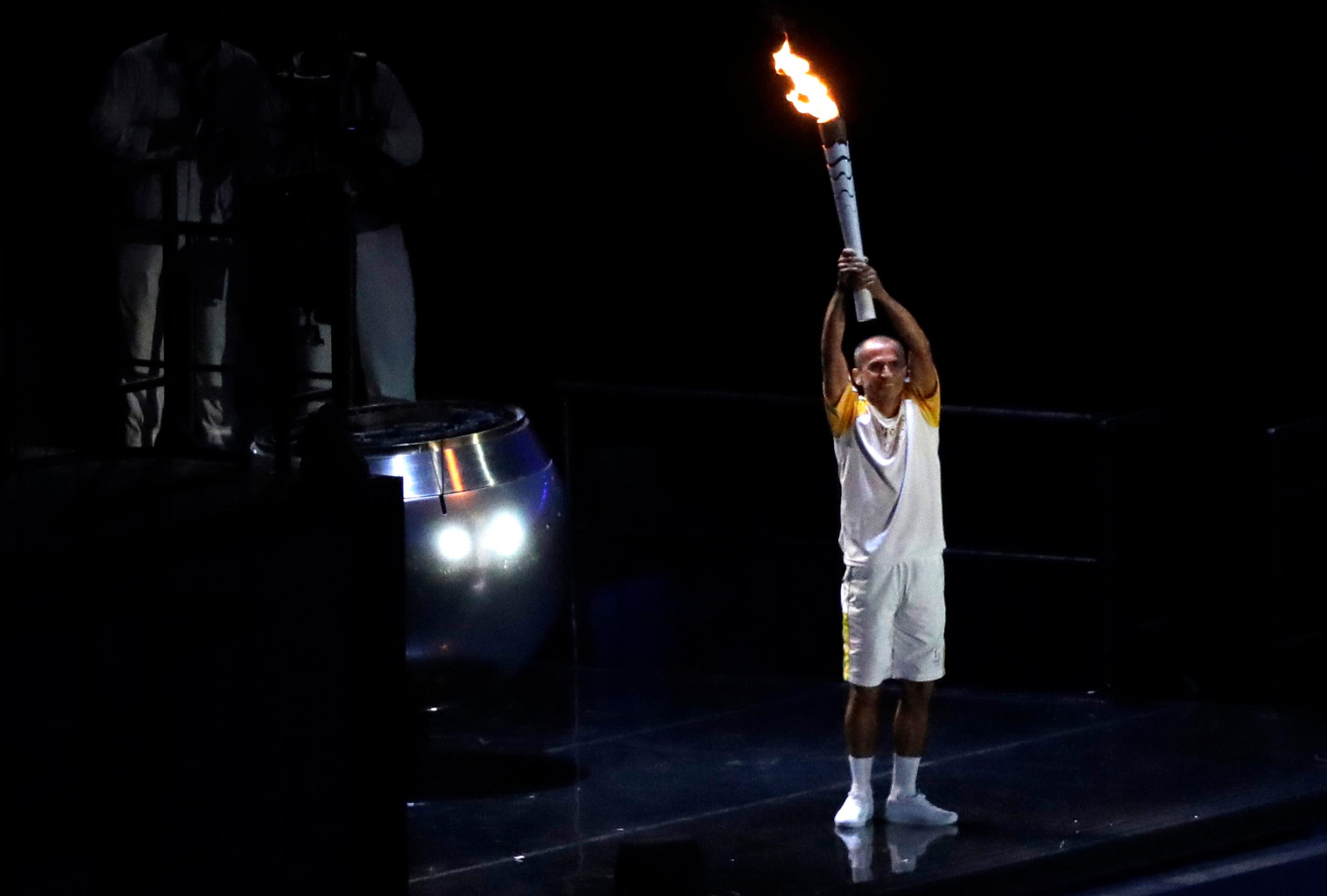 Bývalý maratónec Vanderlei Cordeiro de Lima zapaľuje olympijský oheň.