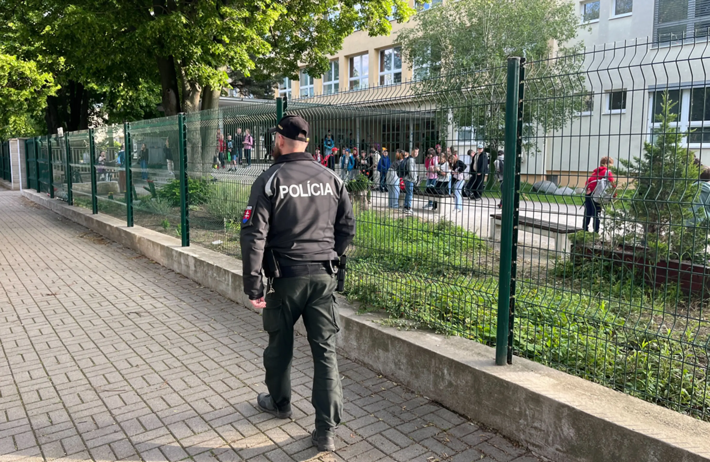 Policajt hliadkuje pred školou v Ivanke pri Dunaji.