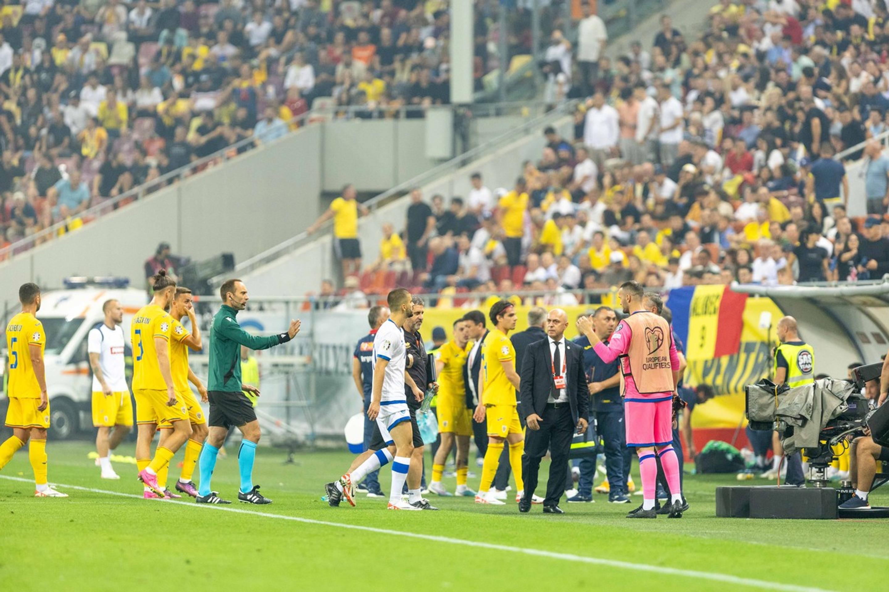 Hráči Rumunska a Kosova opúšťajú hraciu plochu štadióna.