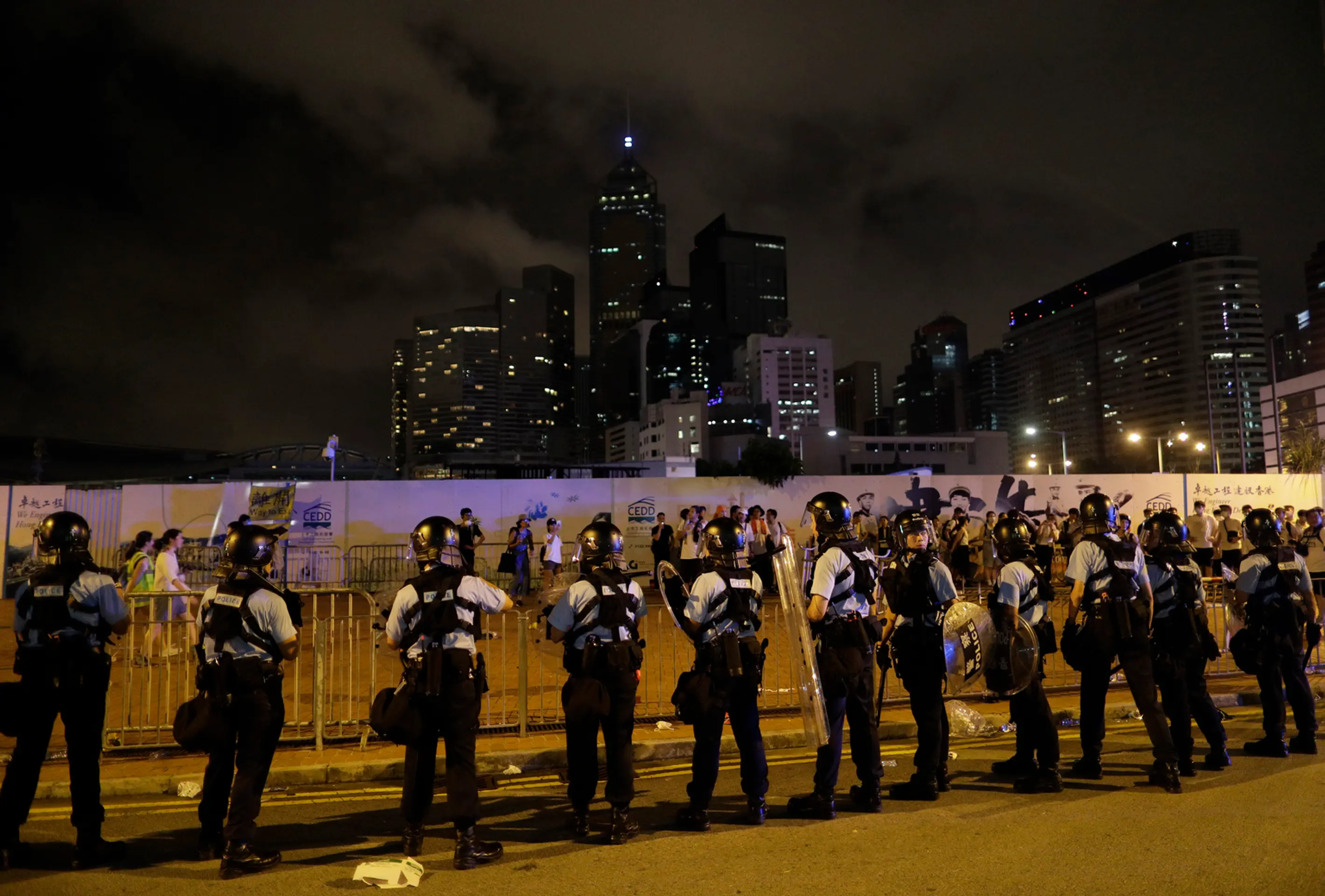 Policajti v Hongkongu zatýkajú počas protestu muža.