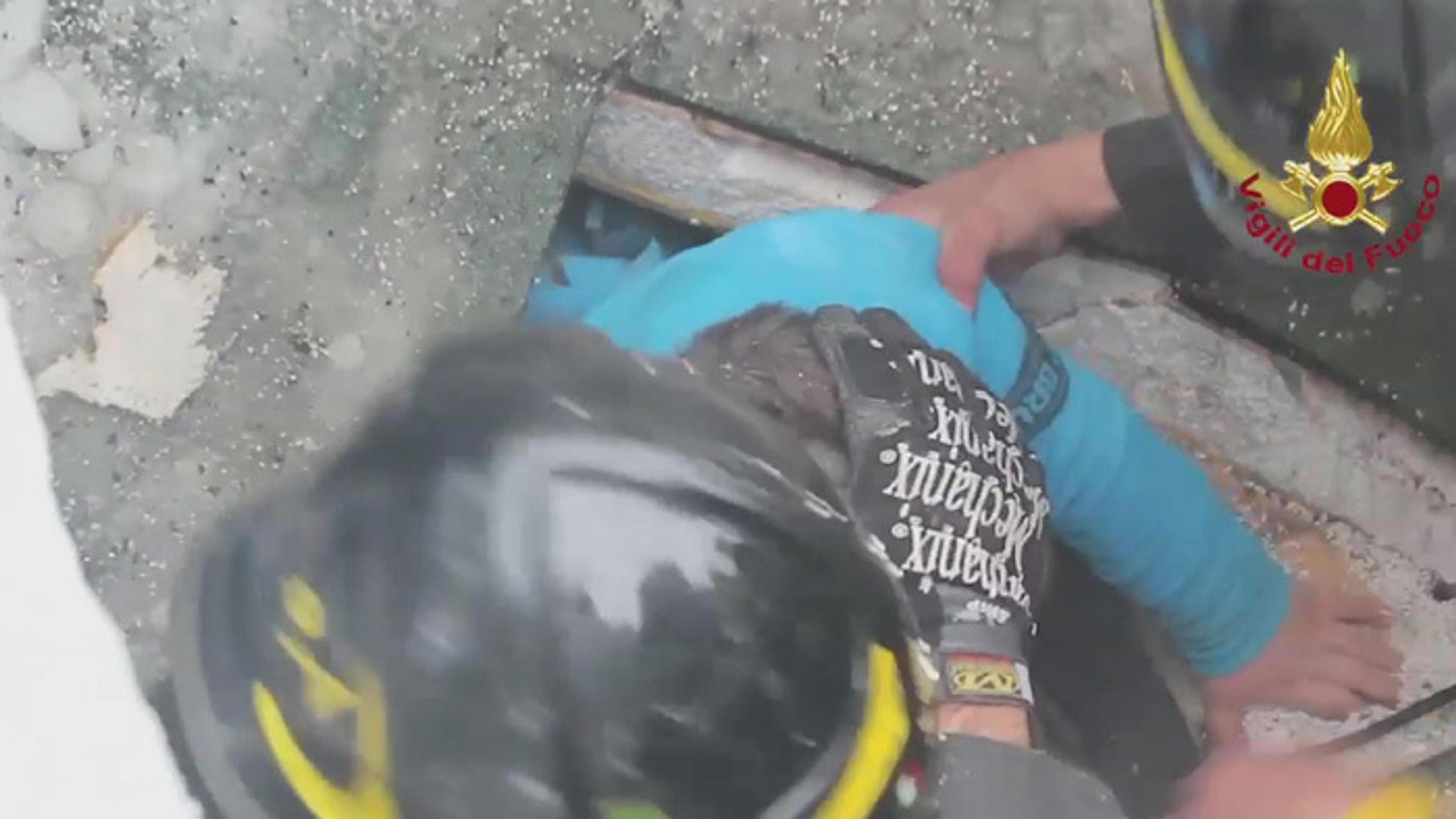 Záchranári vyťahujú spod trosiek preživších.