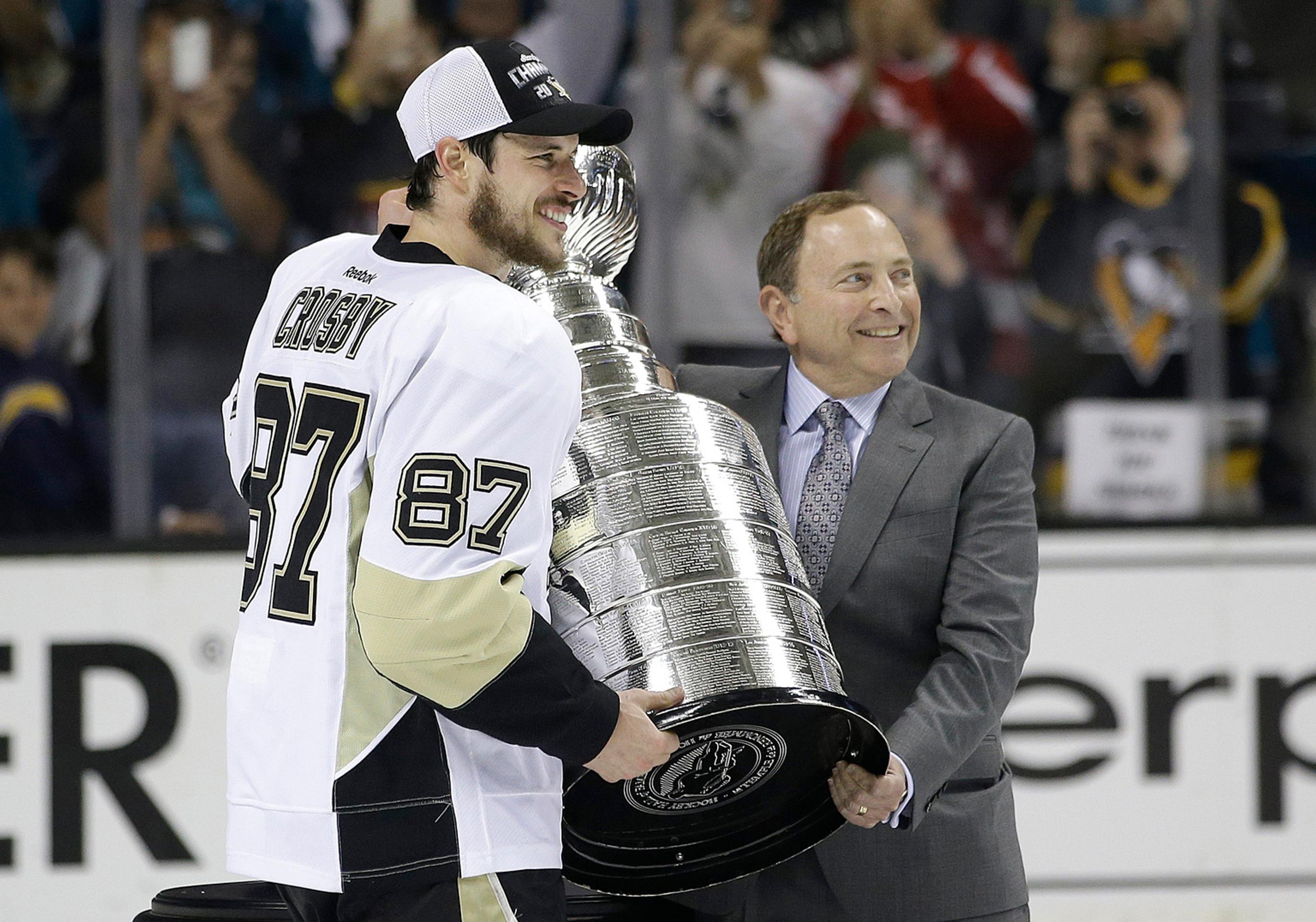 Kapitán Sidney Crosby si preberá Stanley cup z rúk šéfa NHL Garyho Bettmana.